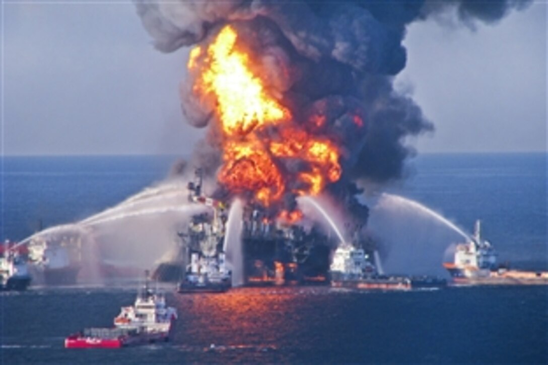 Fire boat response crews battle the blazing remnants of the oil rig Deepwater Horizon off the Louisiana coast in the Gulf of Mexico, April 21, 2010. A Coast Guard MH-65C dolphin rescue helicopter and crew document the fire aboard the mobile drilling unit Deepwater Horizon, while searching for survivors. Multiple Coast Guard helicopters, planes and cutters responded to rescue the Deepwater Horizon's 126 person crew. 
