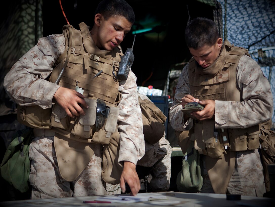Lance Cpl. Brian Berganza reads chart information to Cpl. David A. Esqueda who puts the information into a Centars device for computing safety. Berganza is a horizontal chart operator and Esqueda is an assistant operations chief.