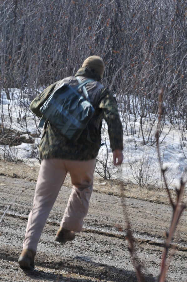 Capt. Kevin Smalley, Marine Attack Squadron 211 pilot, runs across a road to avoid aggressors during survival, evasion, resistance and escape training at the Joint Pacific Alaskan Range Complex in Alaska April 22, 2010.