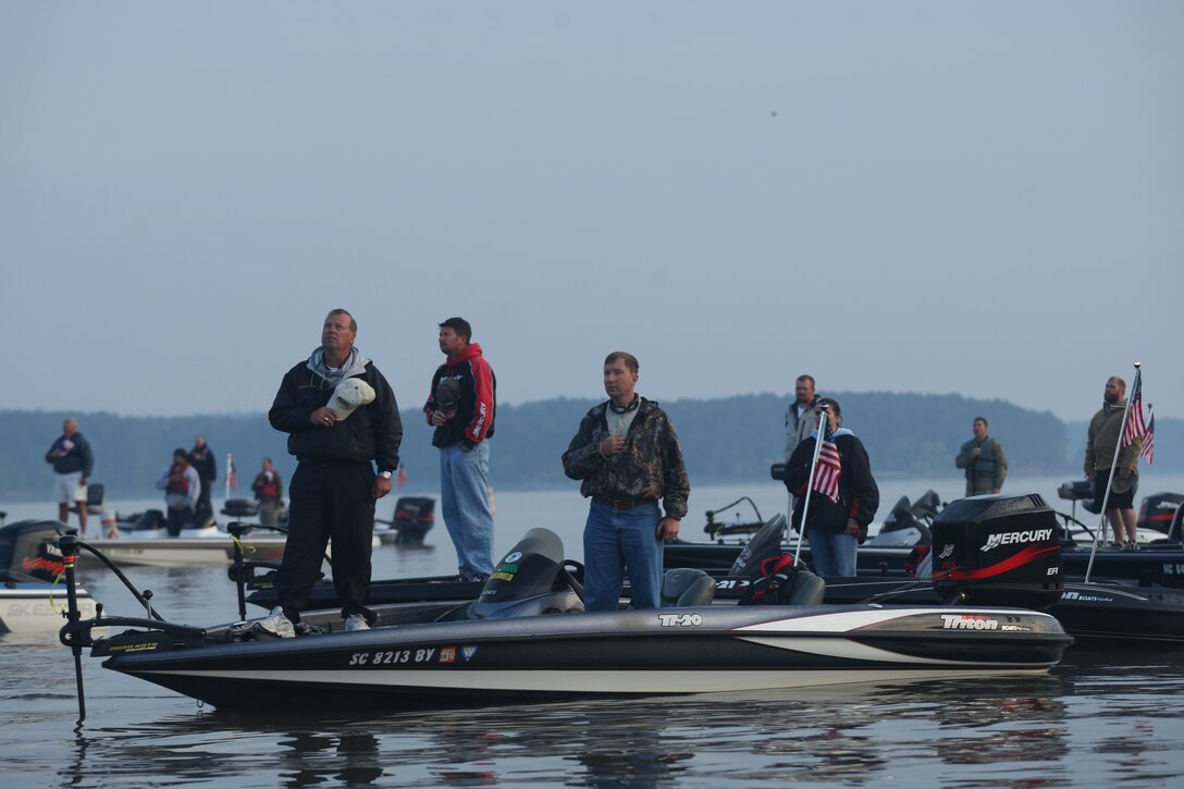 Service members and civilian boaters stand during the playing of the national anthem during the opening ceremony of the 2010 Warriors on the Water Bass Fishing Tournament held at Lake Jordan in Raleigh, N.C., April 23. Service members from across the Department of Defense were given free rods, reels, equipment and use of their teammates’ boats for a day away from the military.