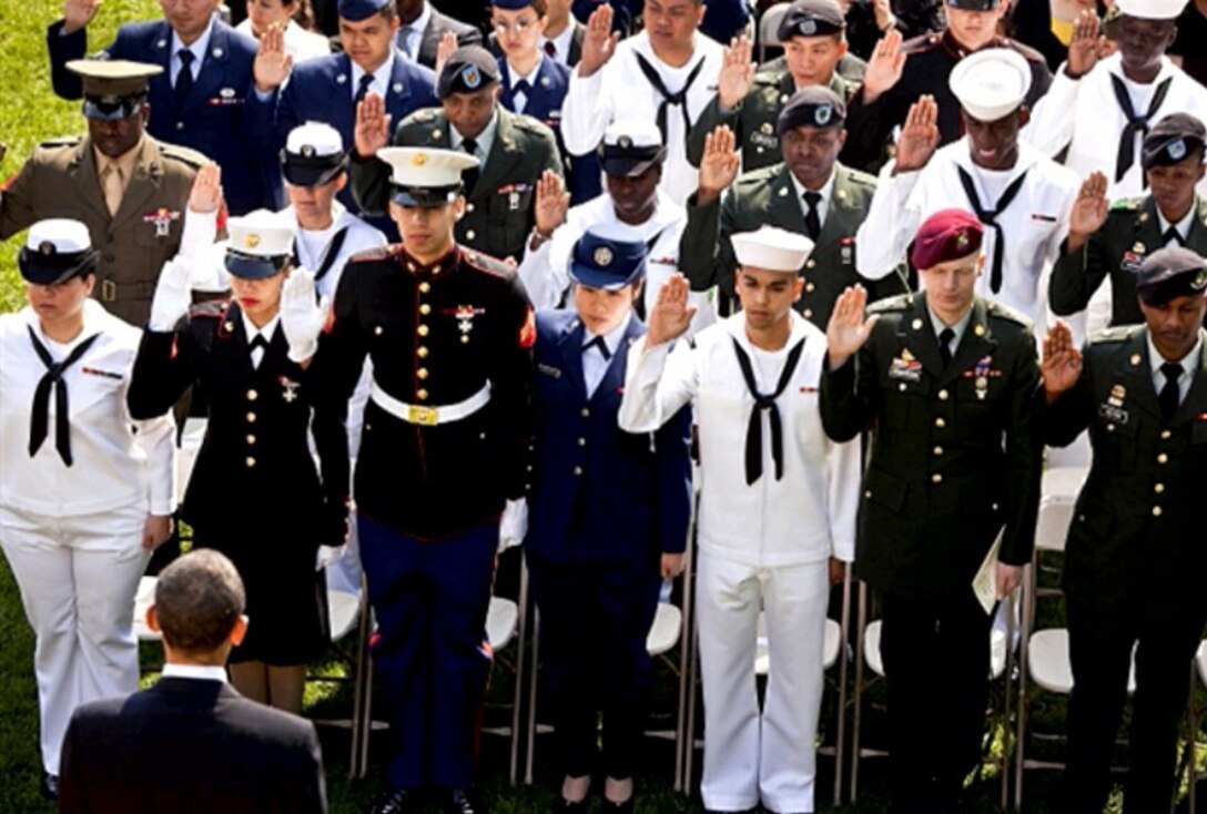 Cpl. Charlyston Schultz (third from left, front row), a personnel clerk with the Installation Personnel Administration Center, Headquarters and Support Battalion, Marine Corps Base Camp Lejeune, stands just a few feet away from President Barack Obama (foreground), during a naturalization ceremony for U.S. service members at the White House, Washington D.C., recently.  Schultz, a native of Uberlandia, Brazil, came to the U.S. in 1998 and became a citizen through serving America in the Marines.