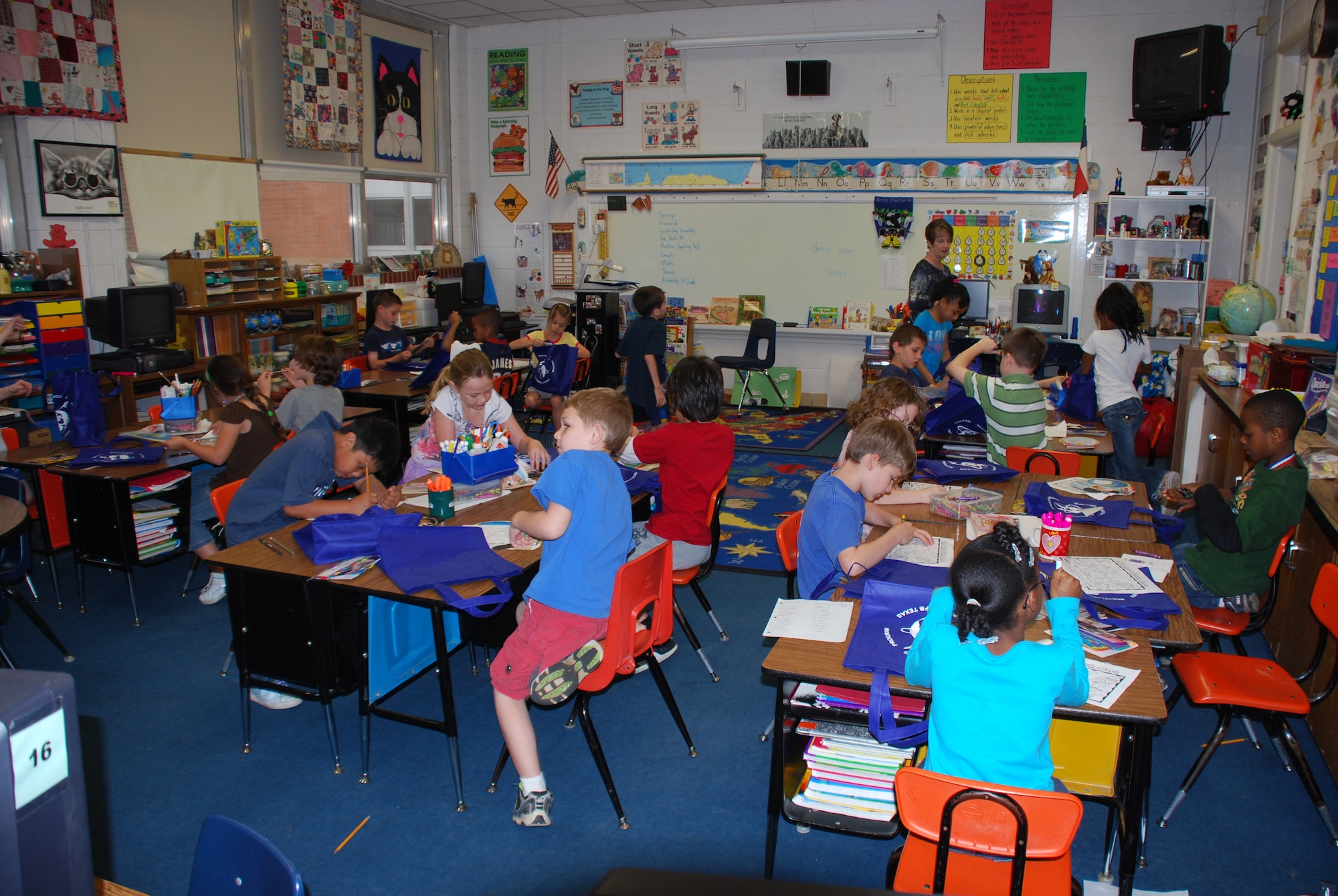 A Sheppard Elementary school second-grade class examines all of the recycling and conservation reminders within the gift bags they received during their Earth Day assembly April 22, 2010.  The bags contained items such as a fun-fact cards shaped like the earth, pencils made out of recycled money and a coloring page labeled “wild about earth” to help keep recycling and conservation in the children’s minds.  (U.S. Air Force photo/Tech Sgt. Vernon Cunningham)