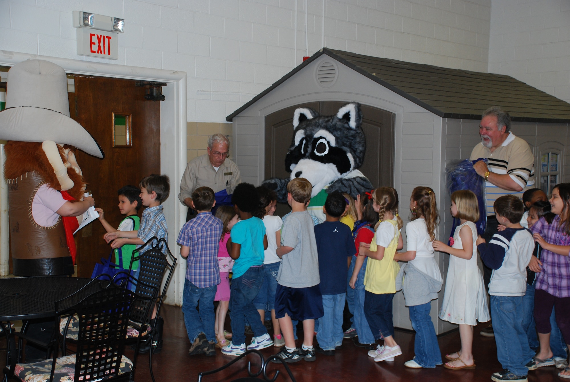 The students of Sheppard Elementary school receive gift bags and information on recycling from the Recycling Ranger (left) and Reggie the Recycling Raccoon (right) as they leave an Earth Day assembly April 22, 2010.  Sheppard Elementary school focused their day around activities intended to raising their student’s awareness on the need to conserve resources and recycle.  (U.S. Air Force photo/Tech Sgt. Vernon Cunningham)