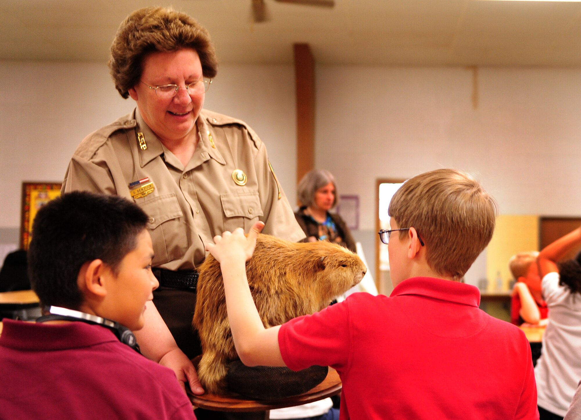 Donna Bentley, Jacksonport State Park interpreter, shows wildlife creatures to students April 22 at Tolleson Elementary School. Ms. Bentley explained how animals, too, conserve and recycle for habitats and hunting in the wild. (U.S. Air Force photo by Senior Airman Steele C. G. Britton)