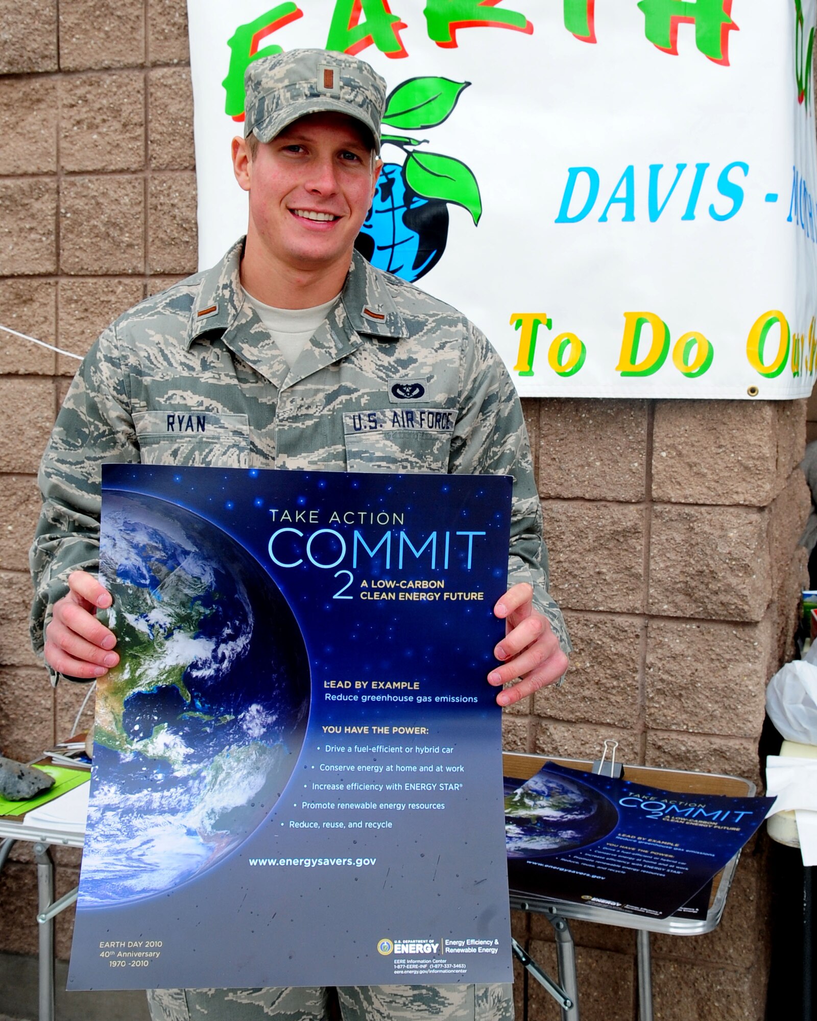 Second Lt. Michael Ryan of the 355th Civil Engineer Squadron, holds up a poster with the theme “Take action and Commit” in celebration of Earth Day at the Base Exchange here April 22. The 355th CES helped bolster D-M Airmen and families observe the 40th annual Earth Day with a display at the Base Exchange, where they handed out informational packets and offered story boards with the base’s energy conservation efforts. (U.S. Air Force photo/Airman Jerilyn Quintanilla)