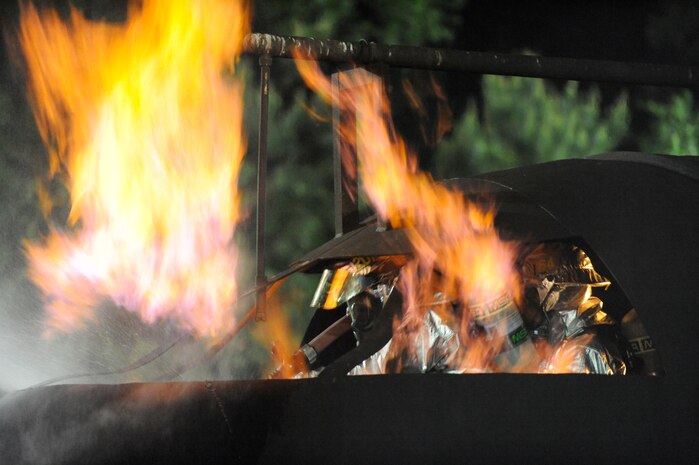 Interior firefighting crews combat a fire, while performing simulated aircraft shutdown procedures at Joint Base Charleston, S.C., April 21, 2010. The fire was part of a training session conducted with Air Force and Navy firefighters from Joint Base Charleston at the crash-fire rescue training facility. The training session was a 24-hour, live-fire training session each base firefighter is required to complete annually. (U.S. Air Force photo/James M. Bowman/released)