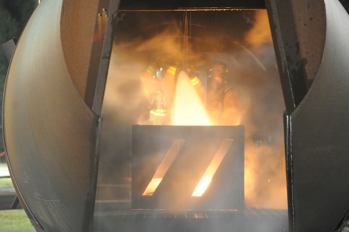 Michael Ruey gives instruction to a firefighting crew during a fire on a simulated aircraft at Joint Base Charleston, S.C., April 21, 2010. The simulation was conducted with Air Force and Navy firefighters from Joint Base Charleston at the crash-fire rescue training facility as part of a 24-hour, live-fire training session each base firefighter is required to complete annually. Mr. Ruey is a fire captain with the 628th Civil Engineer Squadron, Fire Emergency Services Flight. (U.S. Air Force photo/James M. Bowman/released)