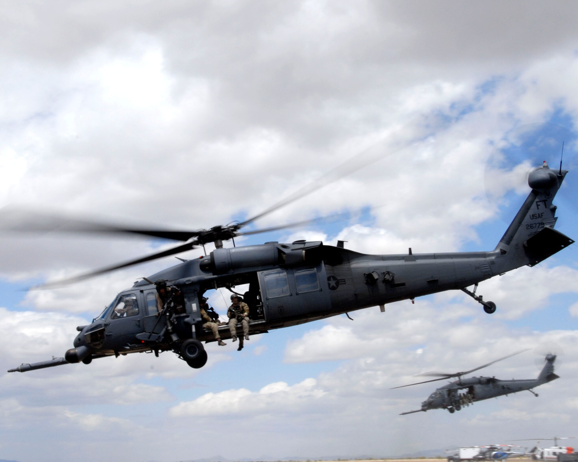 Two HH-60G Pave Hawk rescue helicopters participating in Angel Thunder 2010 take of to rescue survivors of an exercise scenario April 21, 2010 at Bisbee-Douglas International Airport more than 100 miles southeast of Davis-Monthan Air Force Base, Tucson, Ariz. (U.S. Air National Guard photo/Airman 1st Class Jessica Green)