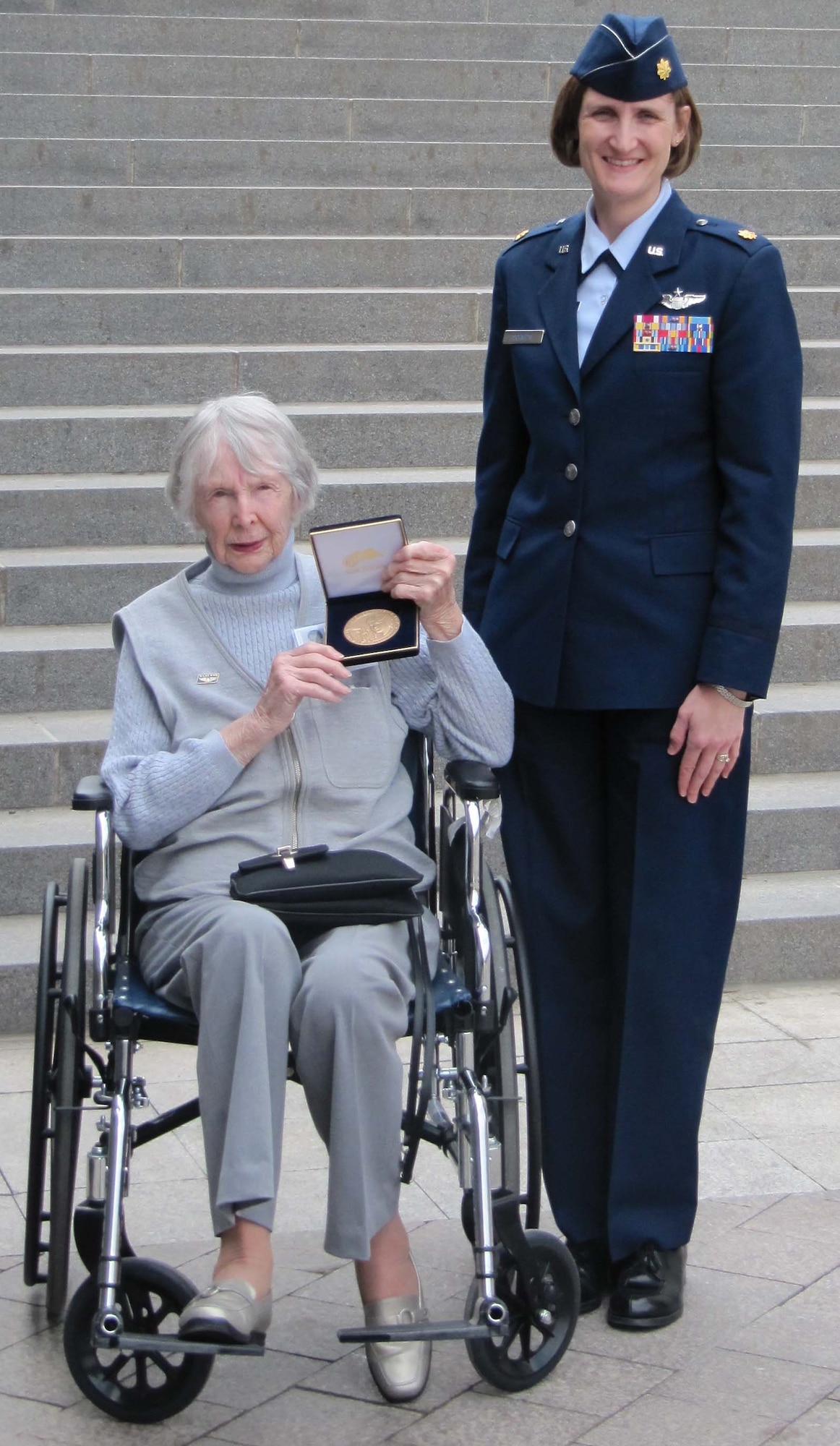 Ms. Phyllis Paradis, a Women Airforce Service Pilot, proudly displays her Congressional Gold Medal along with her military escort for the event, Maj. Leah Schmidt, 18th Air Refueling Squadron which is attached to the 931st Air Refueling Group, McConnell Air Force Base, Kan. Major Schmidt and members of all the branches escorted the attending WASPs at the ceremony and around other events held in the Washington D.C. area to honor the women aviators. (Courtesy Air Force Photo)