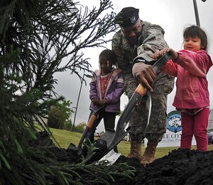 LANGLEY AIR FORCE BASE, Va. - U.S. Army Col. Reggie Austin, 633d Air Base Wing vice commander, helps Zakia James, 4, daughter of Staff Sgt. Crystal Coleman, and Mikaela Zubiate, 4, daughter of Capt. Michelle Zubiate, plant a Japanese Cedar tree at the Russ Child Development Center in honor of Arbor Day April 22. The ceremony, which also coincided with Earth Day, celebrated the Air Force’s commitment to supporting and caring for the environment. (U.S. Air Force photo/Airman Rebecca Montez)