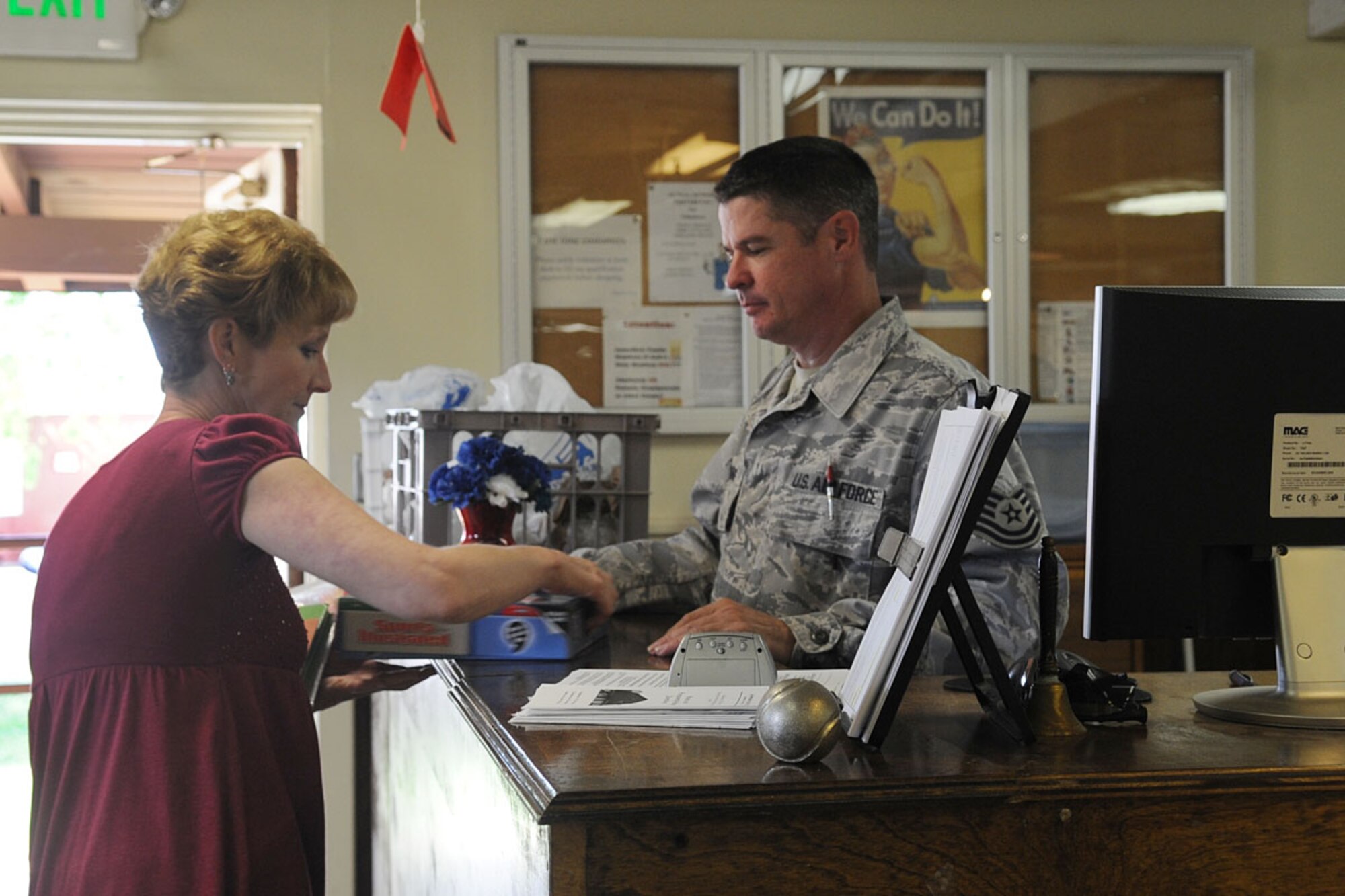 LANGLEY AIR FORCE BASE, Va. -- Tech. Sgt. Samuel Young, (right), 1st Component Maintenance Squadron shop supervisor, helps manager Sara Andreano with a donated item at the Langley Airman's Attic April 22. Young and Andreano are volunteer co-managers of the Attic who put in countless hours to help enlisted Airmen and their dependents with everyday needs. (U.S. Air Force photo/Staff Sgt. Ashley Hawkins) 
