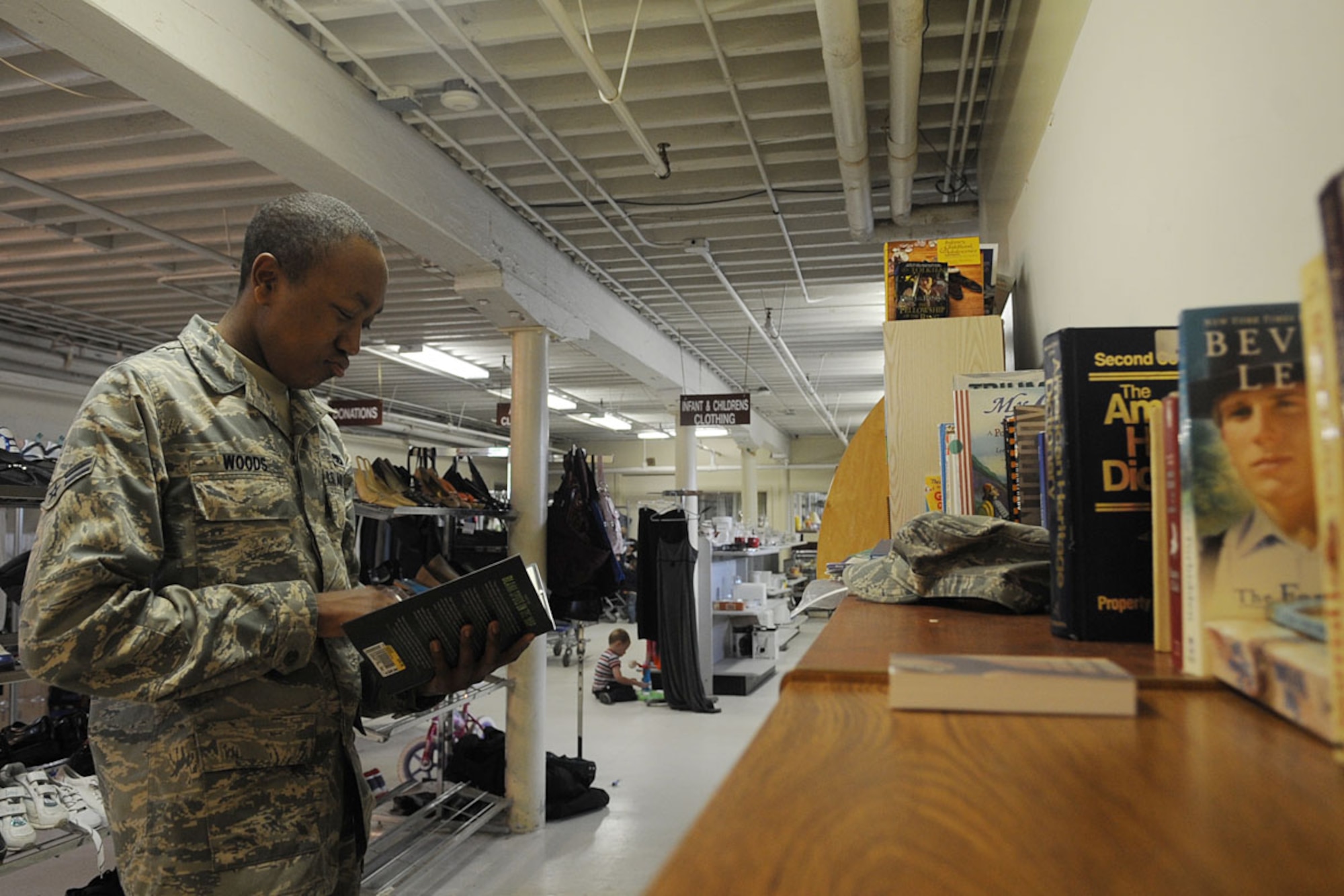 LANGLEY AIR FORCE BASE, Va. -- Airman 1st Class Jordan Woods, 1st Component Maintenance Squadron fuels mechanic, takes a glance over a few free books to take home from the Langley Airman's Attic April 22. Enlisted Airmen E-4 and below and E-5 with dependents are allowed to shop at the Attic. All enlisted Airmen are able to shop on the last day of each month. (U.S. Air Force photo/Staff Sgt. Ashley Hawkins) 