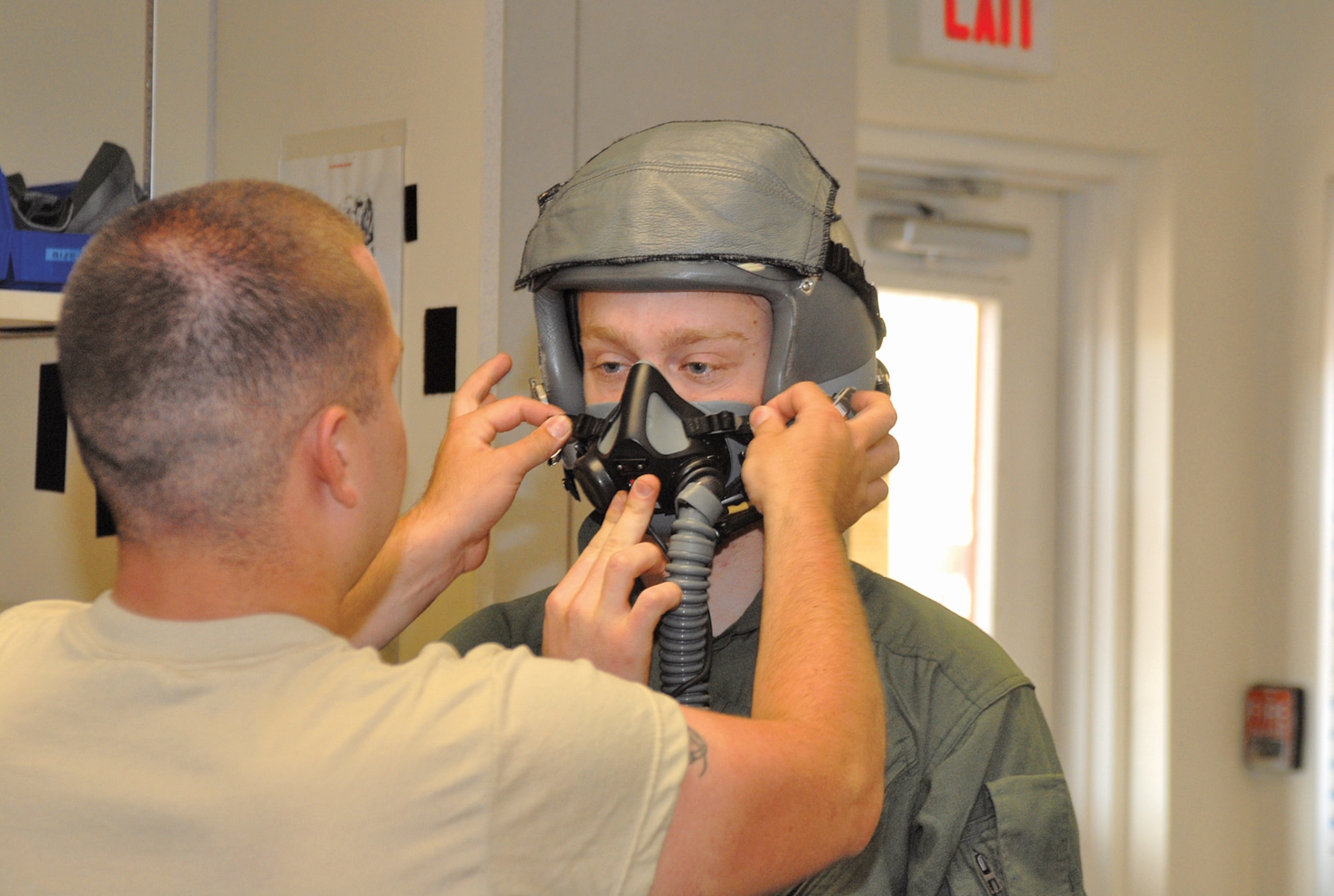 Airman 1st Class Michael Seymour, 62nd Fighter Squadron aircrew flight equipment, tightens an oxygen mask on Bryon Wilson, United States 2010 bronze medalist freestyle skier, before his F-16 flight April 16. (U.S. Air Force photo by Airman 1st Class Sandra Welch)