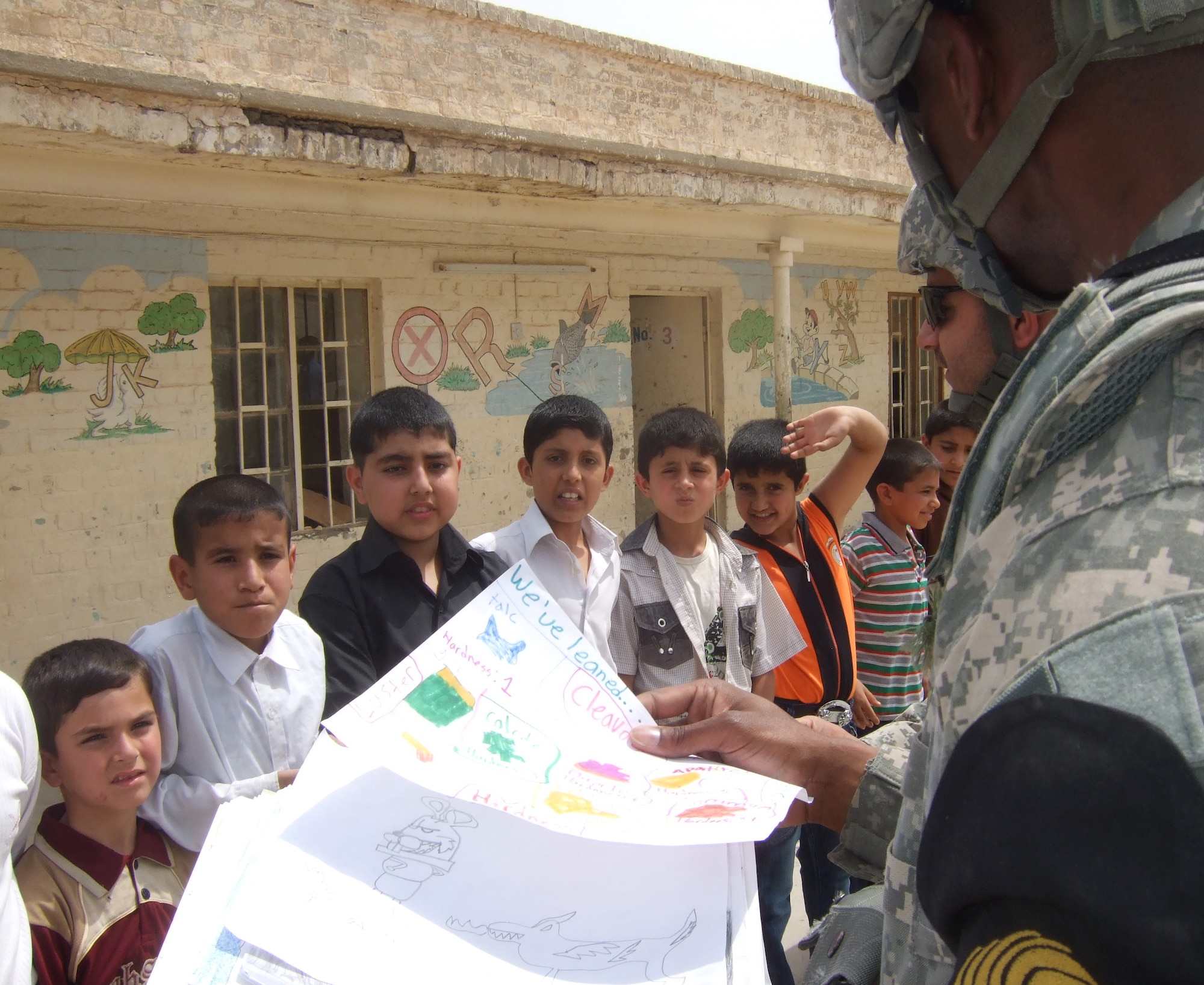 Airmen and Soldiers from Kirkuk Regional Air Base, Iraq, hand out school supplies to local children as part of two programs, Operation Soccer Ball and Operation School Supplies, that are carried out by volunteers at the base.  (U.S. Air Force photo/Senior Airman Blake Draper)