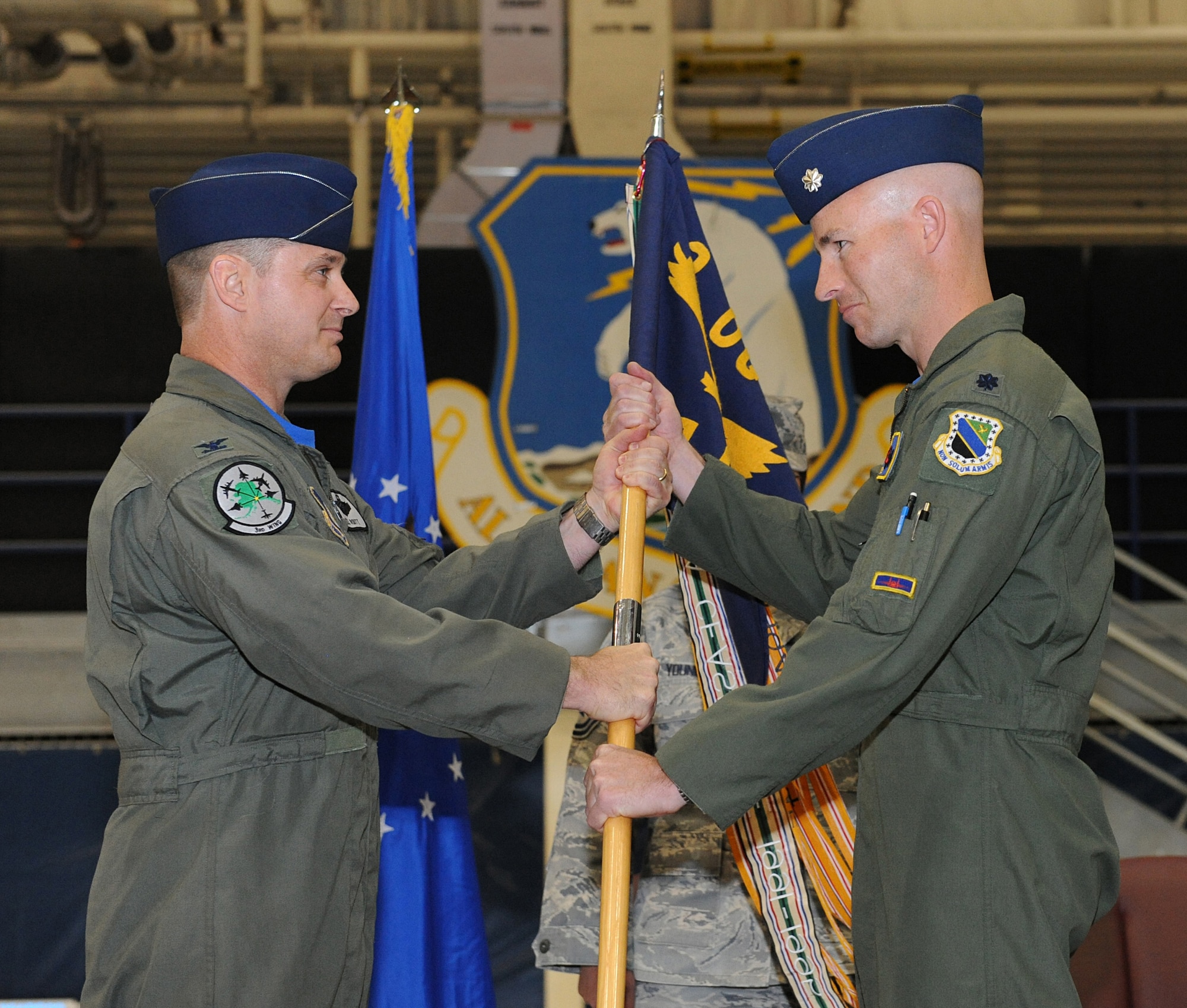 ELMENDORF AIR FORCE BASE, Alaska -- Col. William Routt, 3rd Operations Group commander, passes the 19th Fighter Squadron flag to the new commander Lt. Col. Greg Miller during the 19th FS last change of command ceremony April 16. (Air Force photo by Senior Airman Cynthia Spalding)