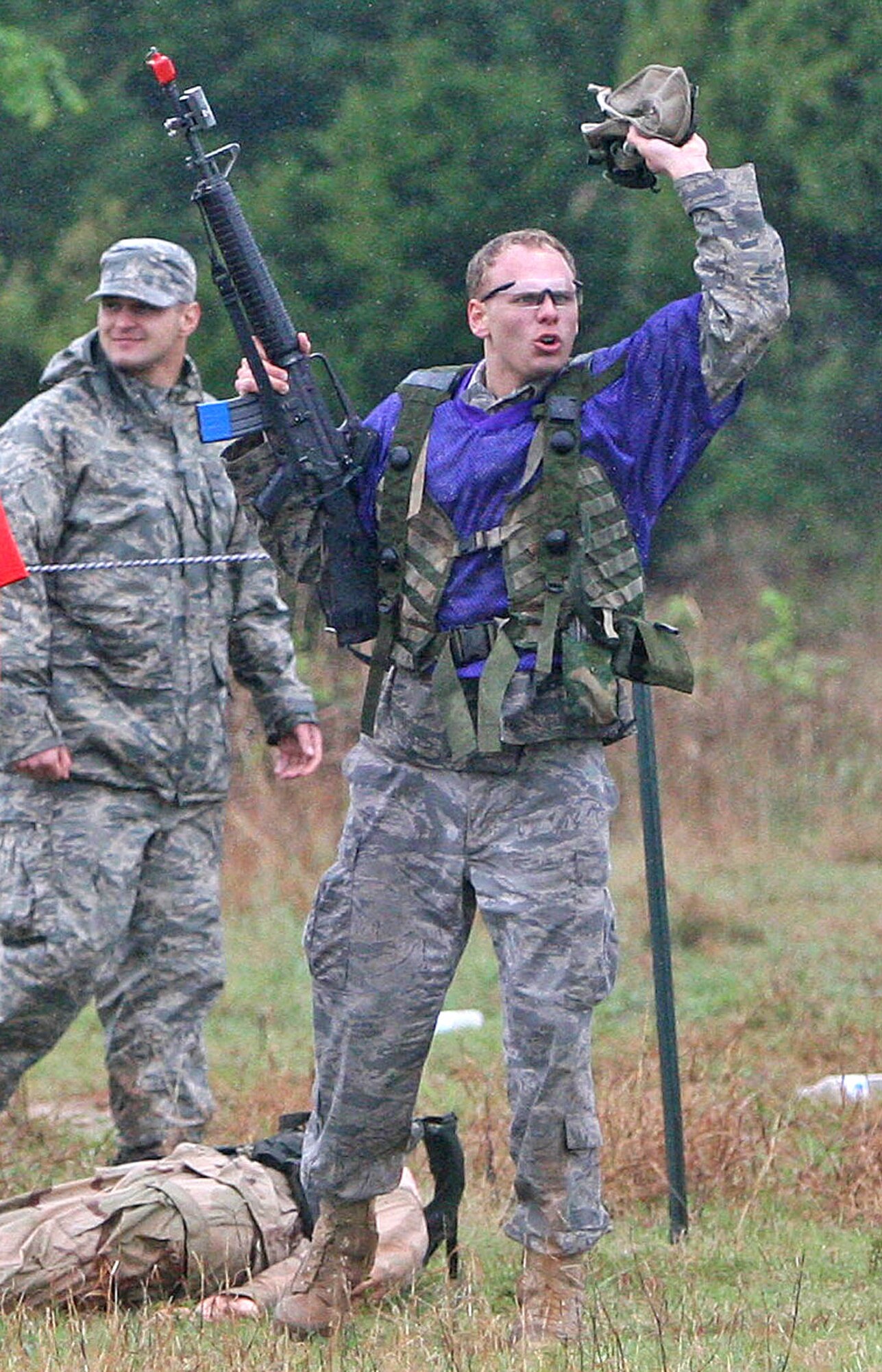Left, Airmen Ryan Byler with the 5th Combat Communications Group celebrates after helping his team to a victory on the capture the flag course. Airman Byler pulled the “flag” — a 160-pound mannequin — back to the starting line while avoiding MILES gear gunfire to win. (Air Force photos by John Stuart)