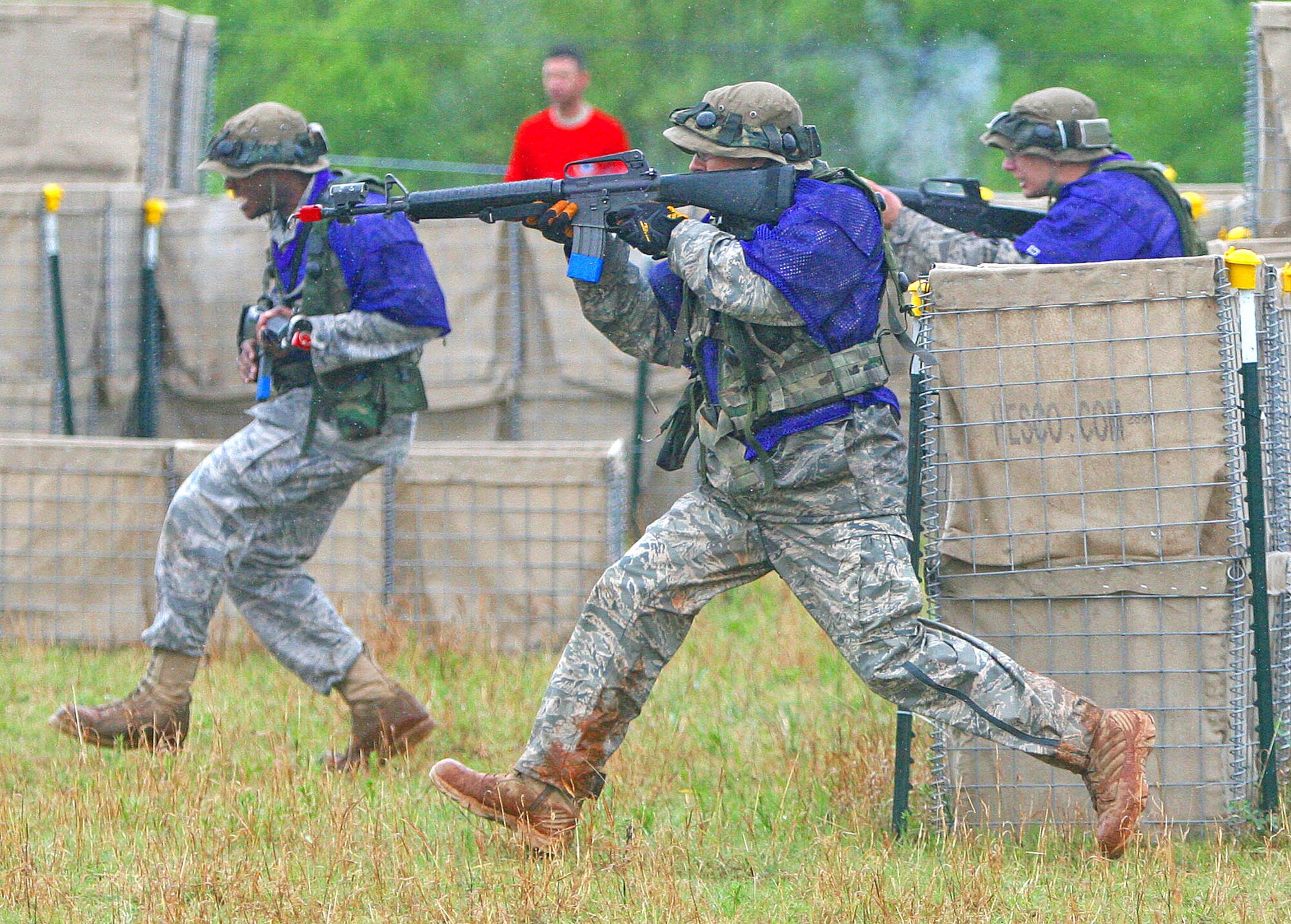 Above, Airmen with the 5th Combat Communications Group from Robins Air Force Base, Ga., move forward with MILES gear and M16s blazing on the capture the flag course Saturday. (Air Force photo by John Stuart0