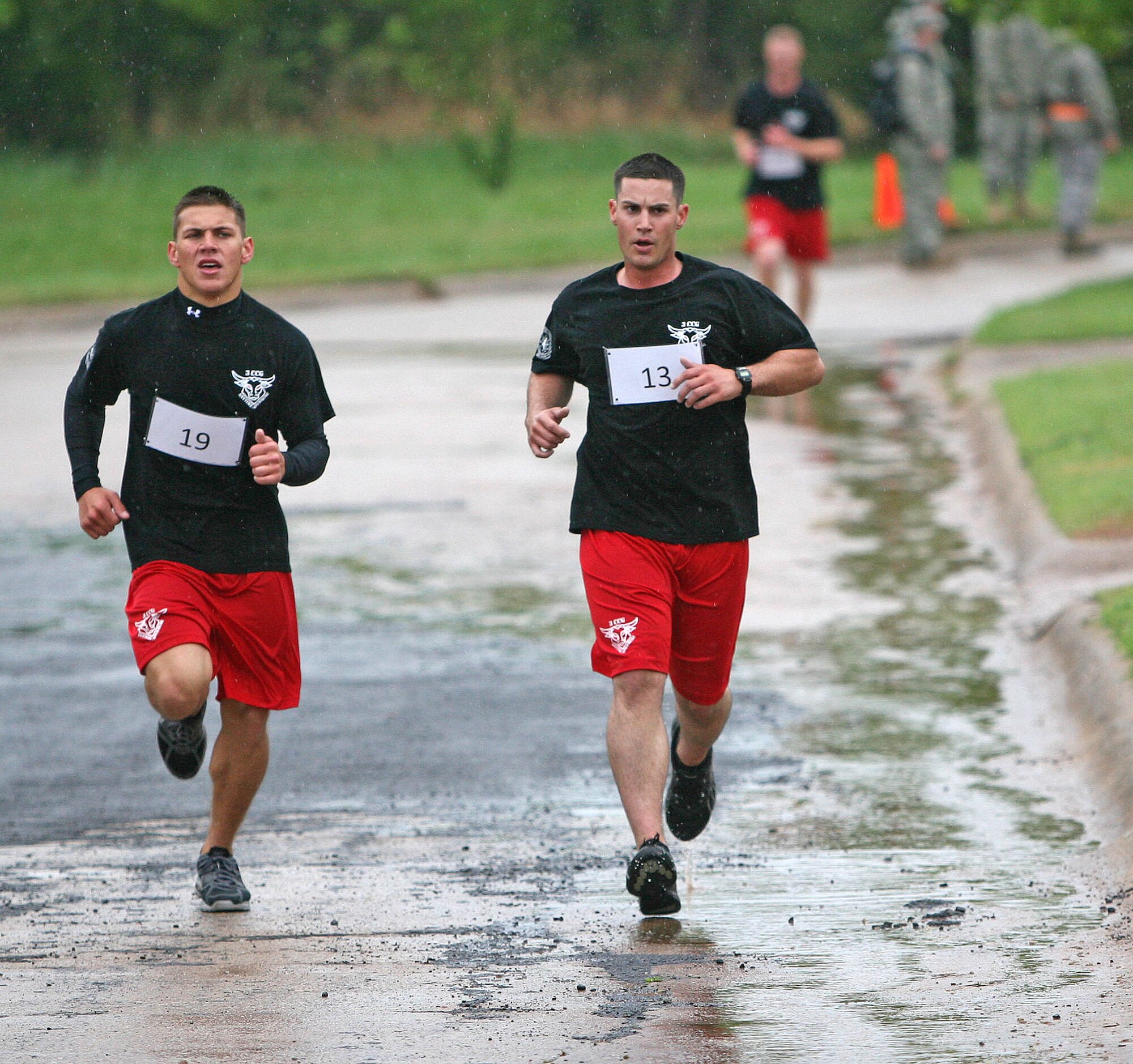 Airman 1st Class Robert Schuster, left, and Staff Sgt. Jarod Williams with the 3rd Combat Communications Group at Tinker, compete in the three-mile run during the PT Challenge April 17 at the Glenwood Training Area. Blustery winds slowed participants down on the PT course that was part of the seven-event “Combat Challenge” Tinker hosted April 16-19. Five combat communications units showed for the competition and the 3rd Herd and 5th Communications Group from Robins Air Force Base won the top spots. (Air Force photos by John Stuart)