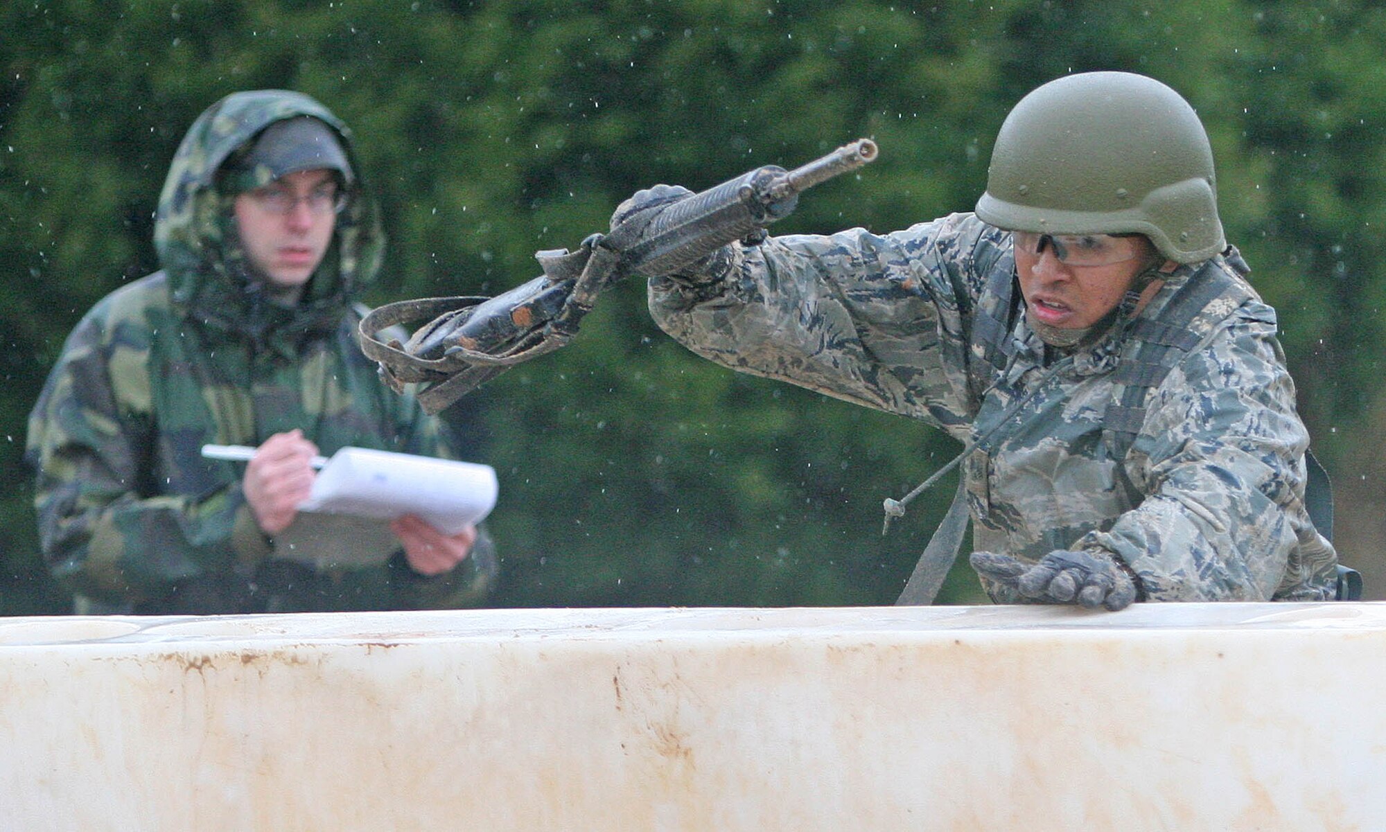 Senior Airman Bricel Cabel of the 201st Combat Communications Group of Hickam Air Force Base, Hawaii, lunges over a barricade April 17 during the Team Tactical Challenge course. Heavy rains saturated the course, making the tactical course challenging for teams and a chilly endeavor for the Air National Guard team from the Aloha State. (Air Force photo by John Stuart)