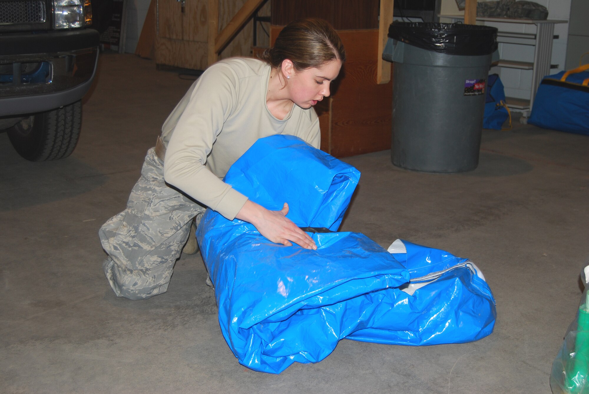 Senior Airman Rebecca Chase, 341st Civil Engineer Squadron emergency management technician, folds up her practice Level A suit April 15. Level A suits are full encapsulated and are chemical slash resistant, using the same zipper used on space suits so that no air can go in or out.(U.S. Air Force photo/Airman 1st Class Kristina Overton)