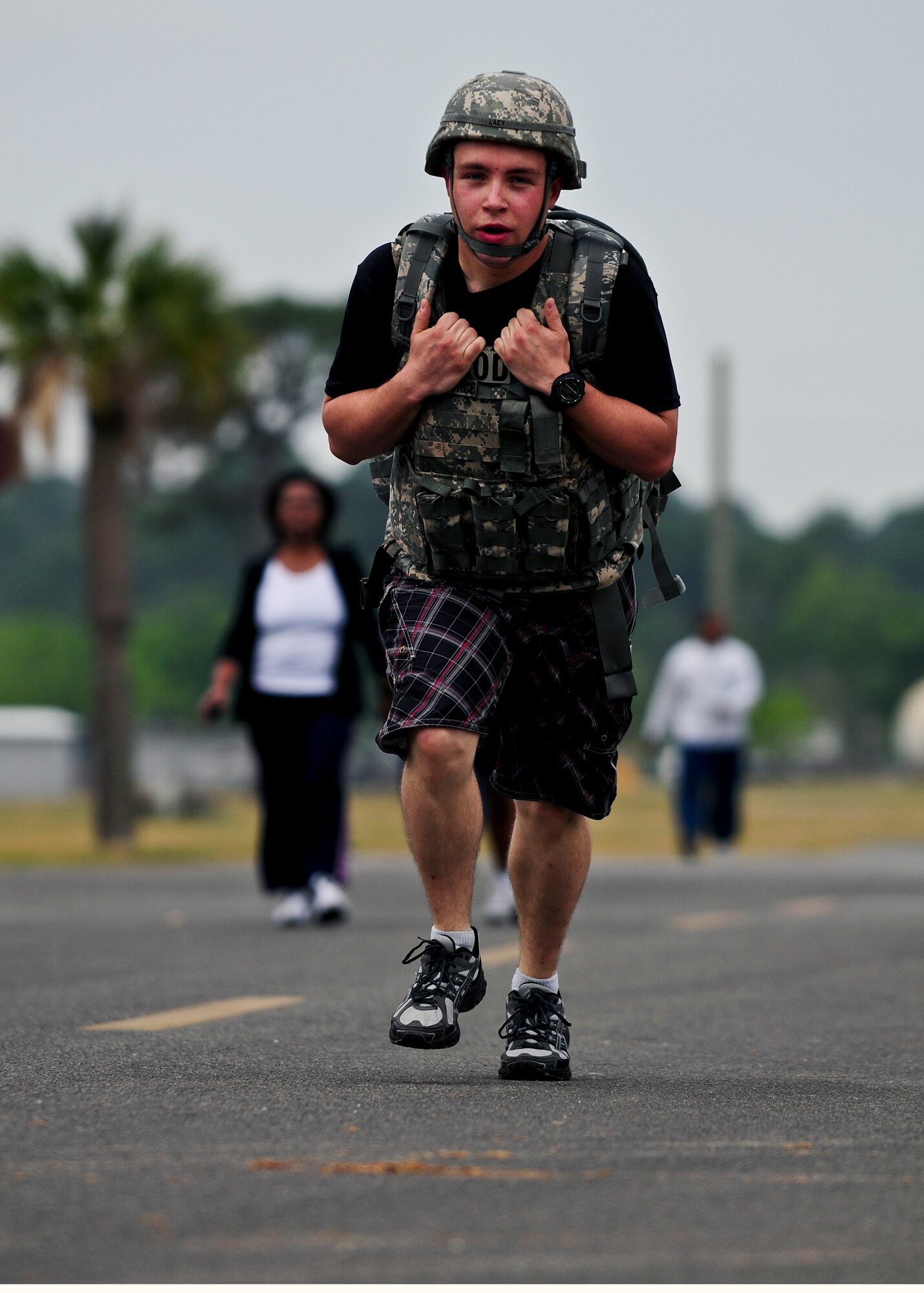 Senior Airman Christopher Lacy, Explosive Ordnance Disposal team member, runs the annual Earth Day 5K in battle helmet and flack vest to prepare for his upcoming deployment April 20 at Eglin Air Force Base.  Airman Lacy said it wasn't bad during the run, but his lower back "did not" like him the next day.  Nearly 130 Team Eglin warriors particpated in the run this year.  The 5K run was part of Eglin’s week-long Earth Day celebration.  (Air Force photo/Scott Moorman.)