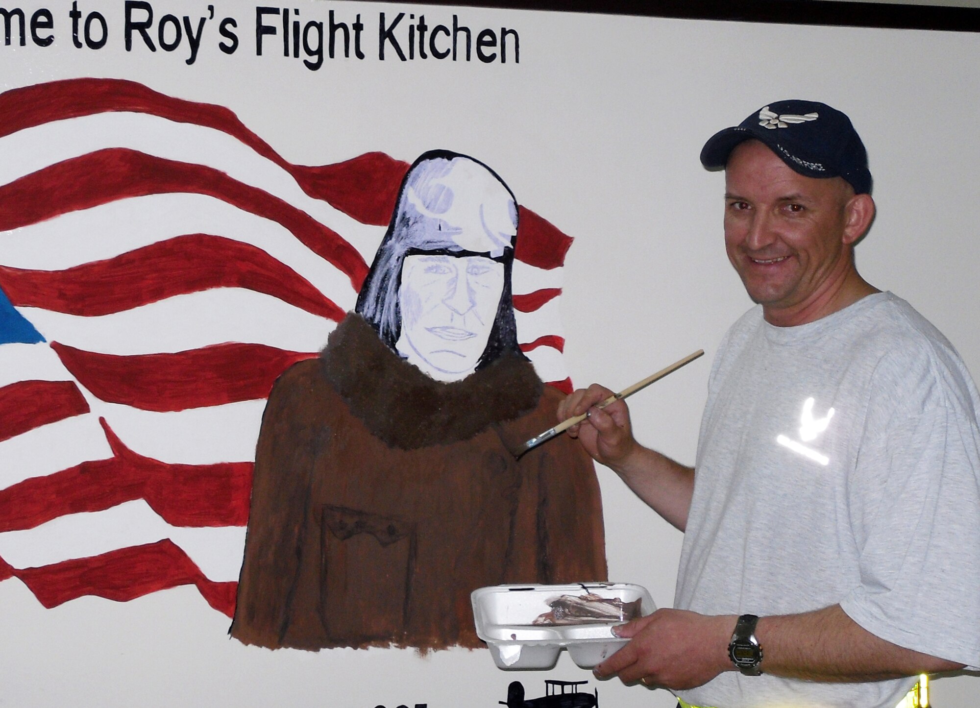 Master Sgt. Scott Sturkol, superintendent of 380th Air Expeditionary Wing Public Affairs at a non-disclosed base in Southwest Asia, works on a mural April 18, 2010 at Roy's Flight Kitchen in the operations area for the wing honoring Master Sgt. Roy Hooe for whom the flight kitchen is named after. Sergeant Hooe is best known for his support of the first air refueling mission with the "Question Mark." Sergeant Sturkol is deployed from the Headquarters Air Mobility Command Public Affairs at Scott Air Force Base, Ill., and his hometown is Wakefield, Mich. (U.S. Air Force Photo/Master Sgt. Scott T. Sturkol/Released)