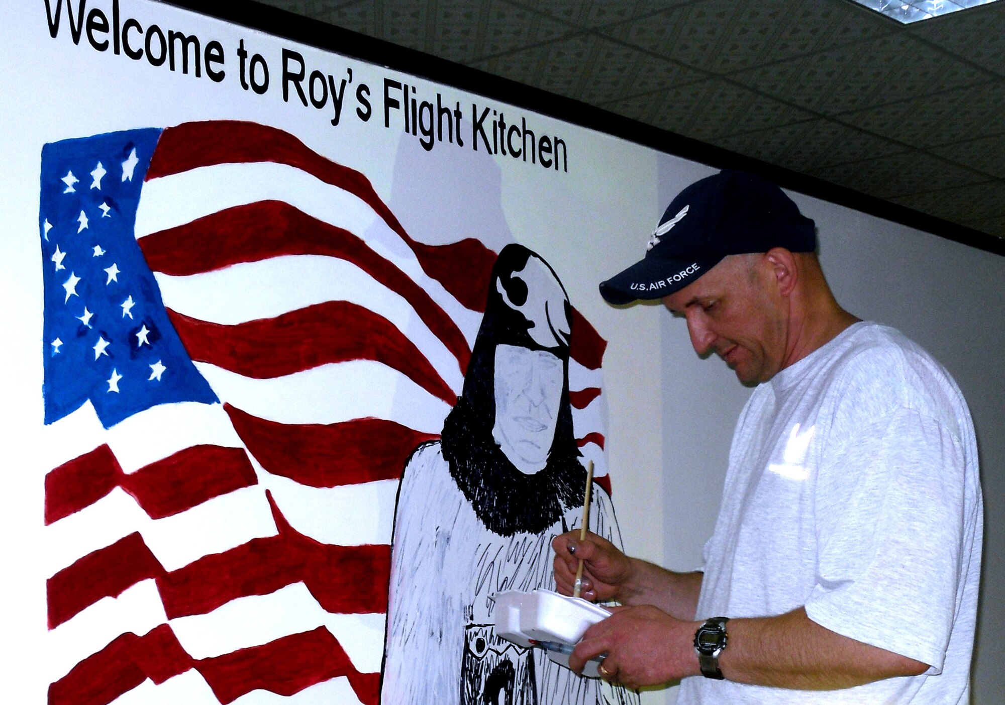 Master Sgt. Scott Sturkol, superintendent of 380th Air Expeditionary Wing Public Affairs at a non-disclosed base in Southwest Asia, works on a mural April 18, 2010 at Roy's Flight Kitchen in the operations area for the wing honoring Master Sgt. Roy Hooe for whom the flight kitchen is named after. Sergeant Hooe is best known for his support of the first air refueling mission with the "Question Mark." Sergeant Sturkol is deployed from the Headquarters Air Mobility Command Public Affairs at Scott Air Force Base, Ill., and his hometown is Wakefield, Mich. (U.S. Air Force Photo/Master Sgt. Scott T. Sturkol/Released)