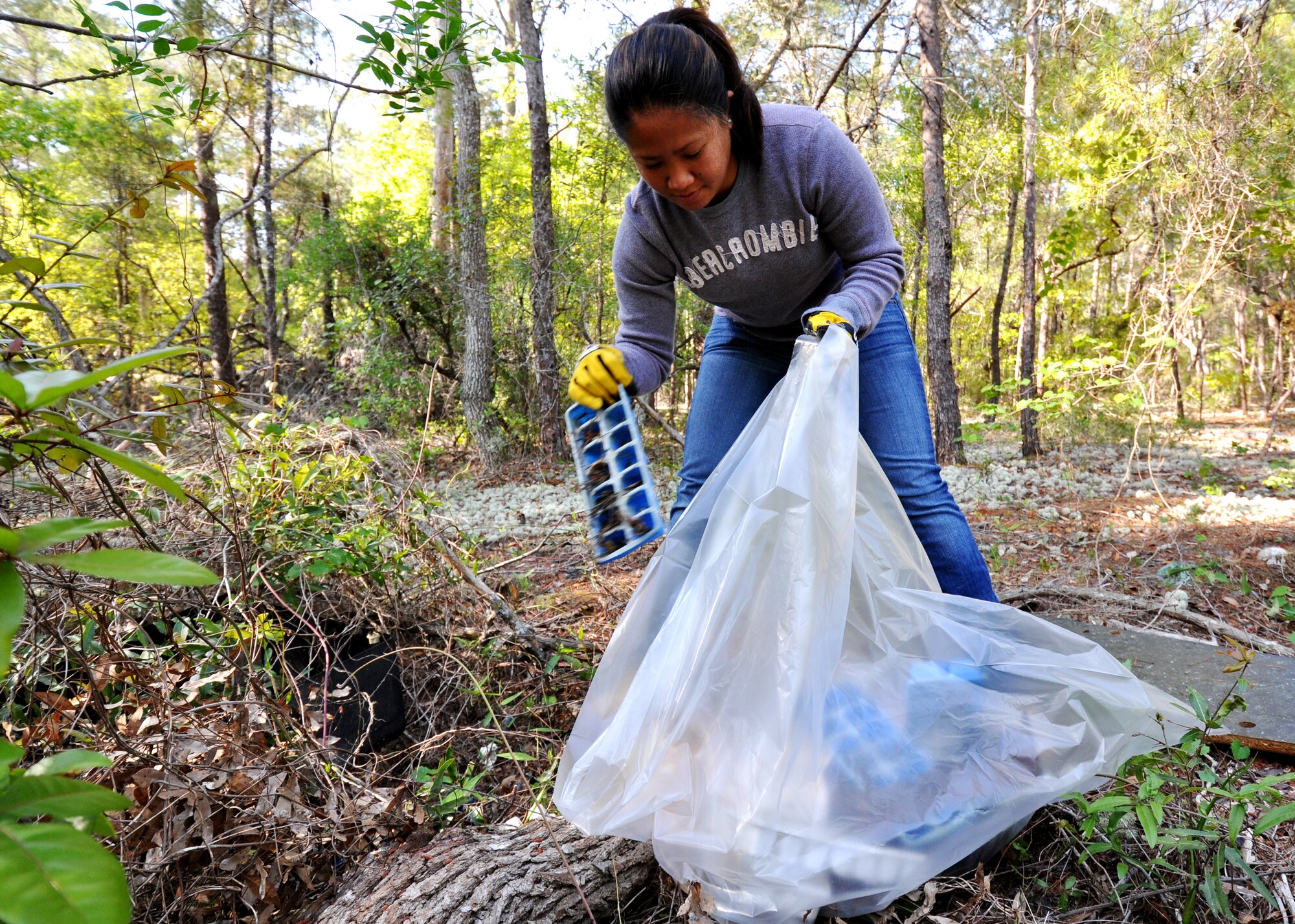 Senior Airman Levi Santos, 96th Logistics Readiness Squadron, gathers up ice trays found throughout the Eglin Air Force Base range April 21.  30 volunteers picked up 5,400 pounds of garbage this year.  The range clean-up is an annual event that coincides with Earth Day.  (U.S. Air Force photo/Airman 1st Class Anthony Jennings.)
