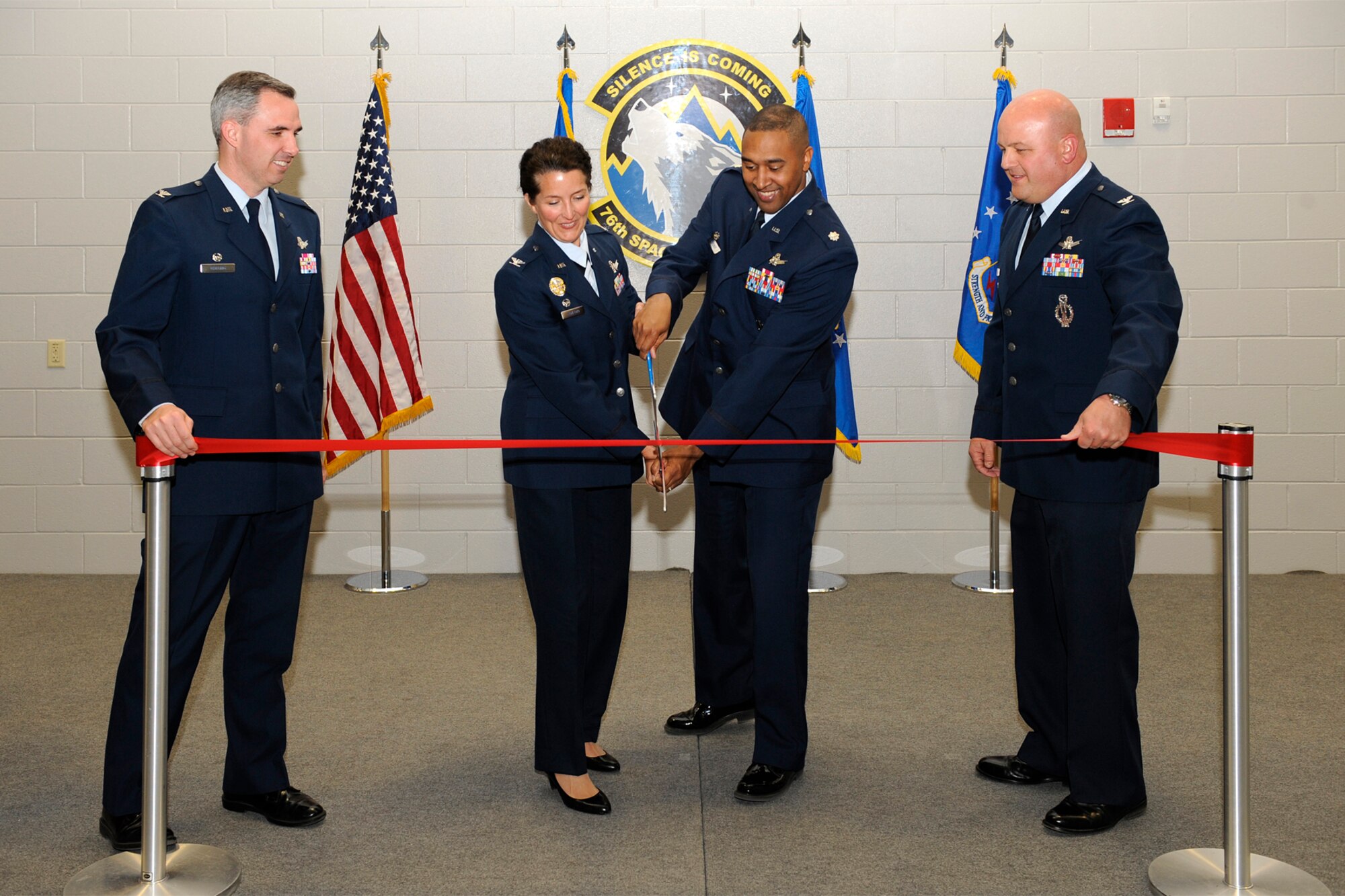 Col. Nina Armagno, 21st Operations Group commander and Lt. Col. Elvert Gardner, 76th Space Control Squadron commander, with Col. Stephen N. Whiting, 21st Space Wing commander, (left) and Col. Jim Jennings (right), 21st Space Wing vice commander, cut a ceremonial ribbon April 5 to mark the grand opening of the 76th SPCS new facility, Building 2028 on Stewart Avenue. The 76th SPCS had been operating in Hangar 104 on the flightline while the new state-of-the-art building was under construction. The facility, also known as the Lobo’s Den, is more than 34,000 square feet and allows the 76th SPCS to defend the United States’ space superiority from anywhere on the globe. (U.S. Air Force photo/Craig Denton)