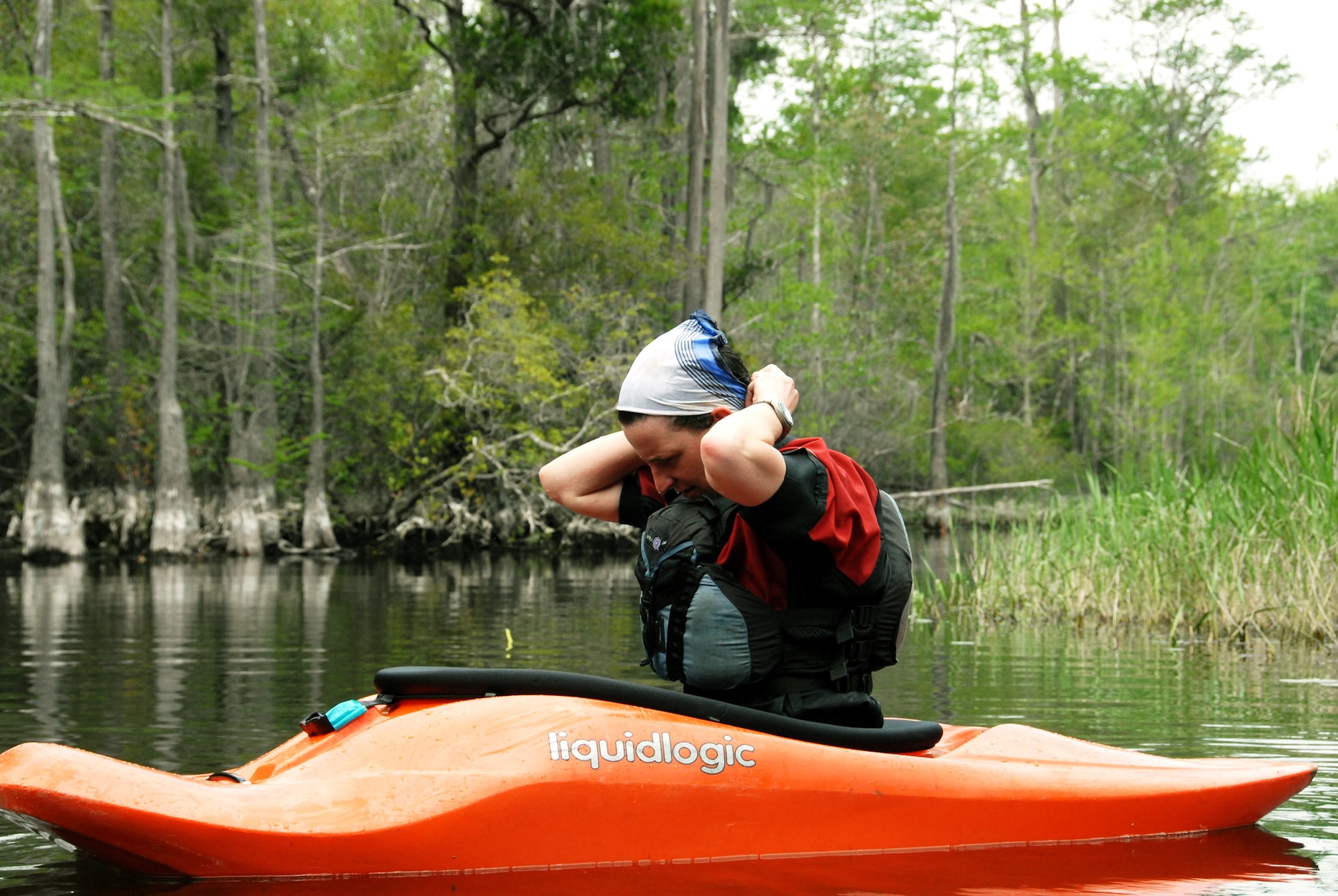 Airman 1st Class Jennifer Pettus, 96th Medical Operations Squadron, readjusts her newly-soaked bandanna April 19 during the first-ever Kayak tour through the Eglin Air Force Base range.  The five and a half mile kayak tour took 10 people down Boiling Creek and the Yellow River deep within the Eglin range.  The scenic tour showed off Eglin’s unique wild and plant life.  It kicked off Eglin’s week-long Earth Day celebration.   (U.S. Air Force photo/Samuel King Jr.)