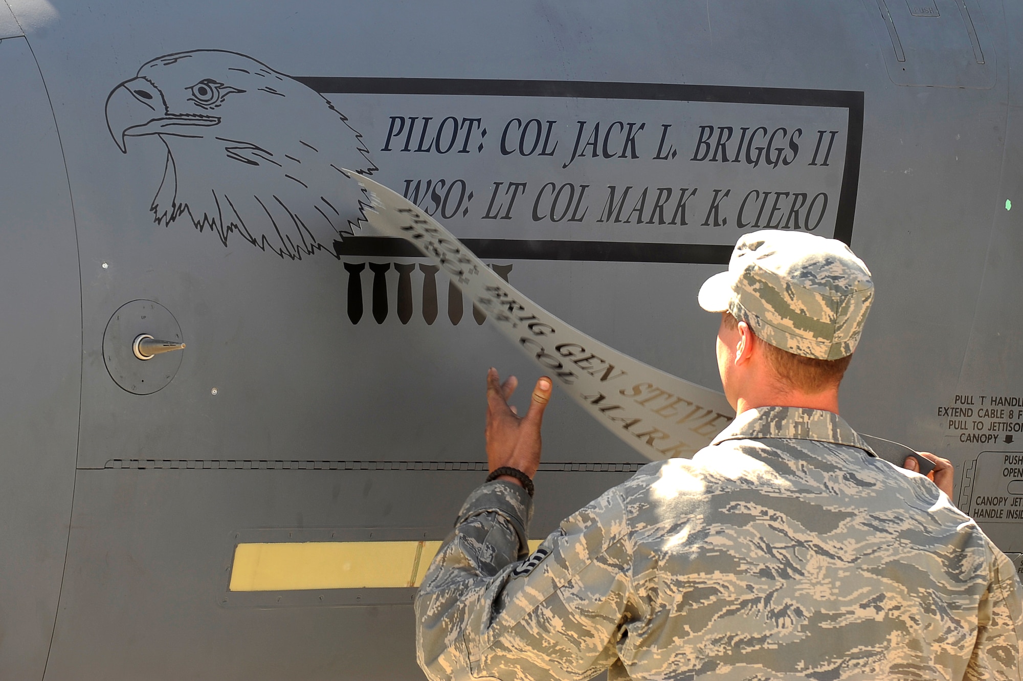 The name of U.S. Air Force Col. Jack Briggs II, commander, 455th Air Expeditionary Wing, is revealed on an F-15E during the change of command ceremony at Bagram Airfield, Afghanistan, April 23, 2010. (U.S. Air Force photo by/ Tech. Sgt. Jeromy K. Cross/released)