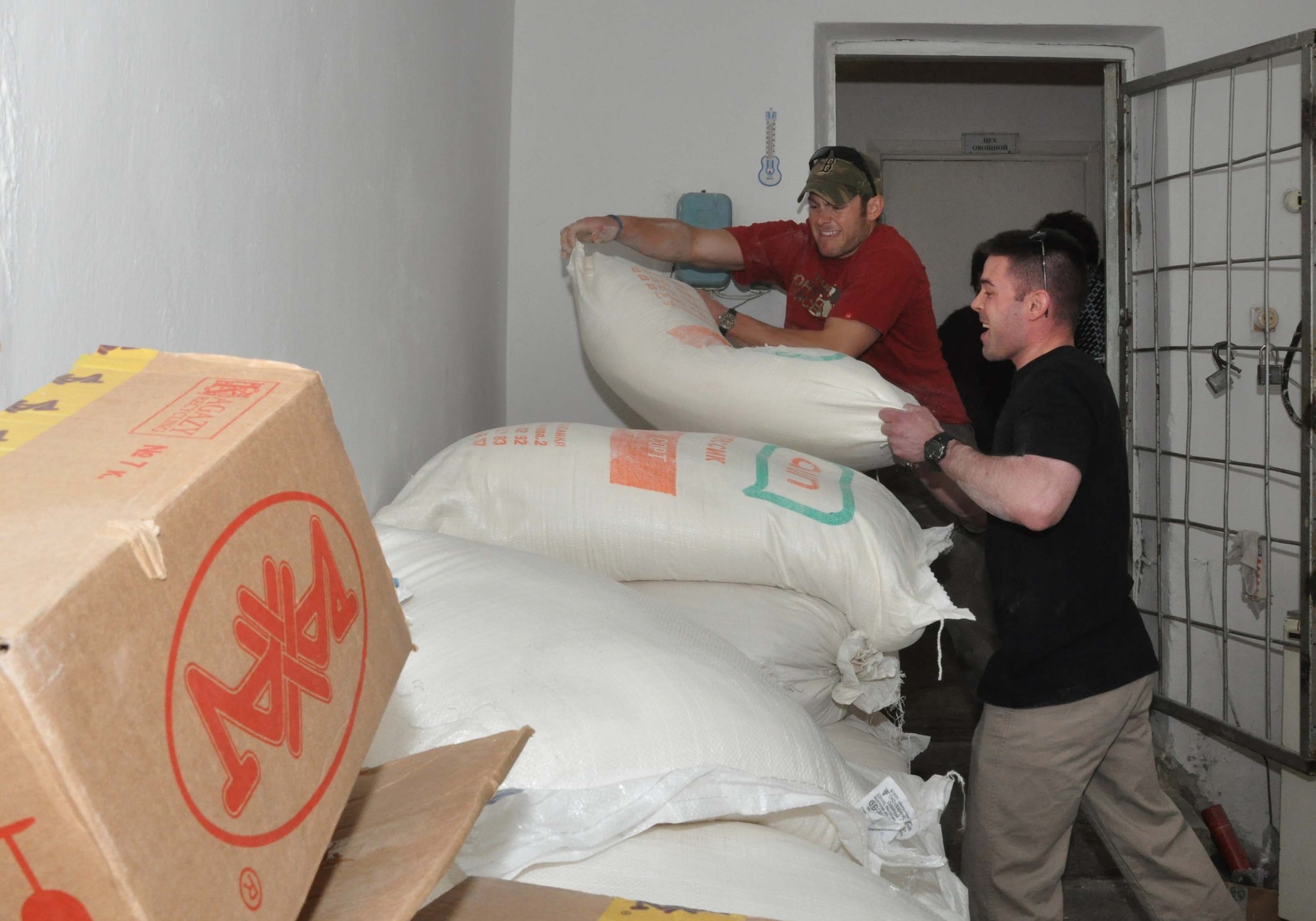 Military service members from the Transit Center at Manas, Kyrgyzstan, stockpile 100-pound bags of flour into the Sokulukskaya Special Boarding School/orphanage for children April 23, 2010. Most of the 270 children there have had or need cleft palette surgery. (U.S. Air Force photo/Staff Sgt. Carolyn Viss)