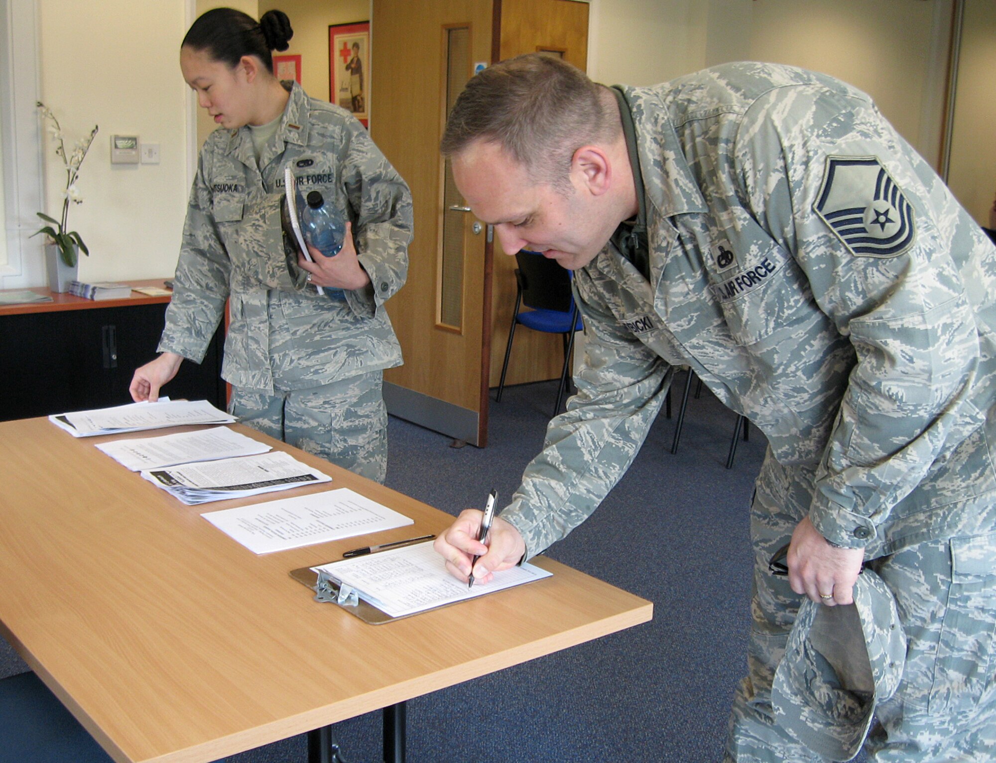 Master Sgt. David Szybicki, 748th Aircraft Maintenance Squadron, and 2nd Lt. Kellianne Matsuoka, 48th Aircraft Maintenance Squadron, sign into the sponsorship training class at the Lakenheath Airman & Family Readiness Center April 23.  This class is meant to familiarize Liberty Wing sponsors with the new electronic sponsorship application training, or eSAT, module that standardizes the sponsorship program Air Force-wide. (U.S. Air Force photo/Capt. Alysia Harvey)