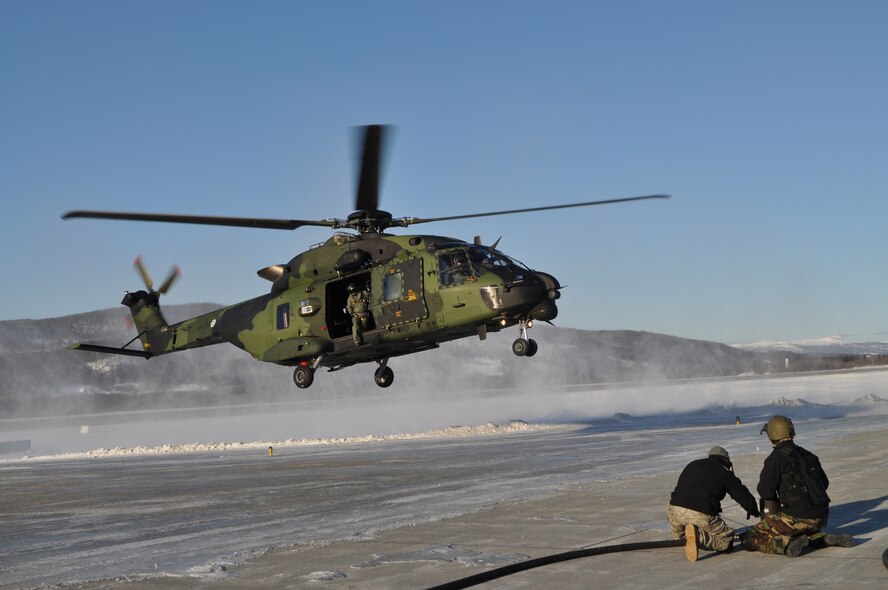 EVENES, Norway – Senior Airman Brent Reich and Staff Sgt. Max Horner, 352nd Special Operations Group forward area refueling point team members, await the landing of a German NH-90 during Exercise Cold Response 10, an annual multinational training exercise.  The team conducted several practice FARP missions during daylight, but actual FARP missions are done in total darkness.   More than 200 352nd SOG members deployed to CR10 which involved more than 8,000 participants from 14 nations.  (U.S. Air Force photo/Tech. Sgt. Marelise Wood)