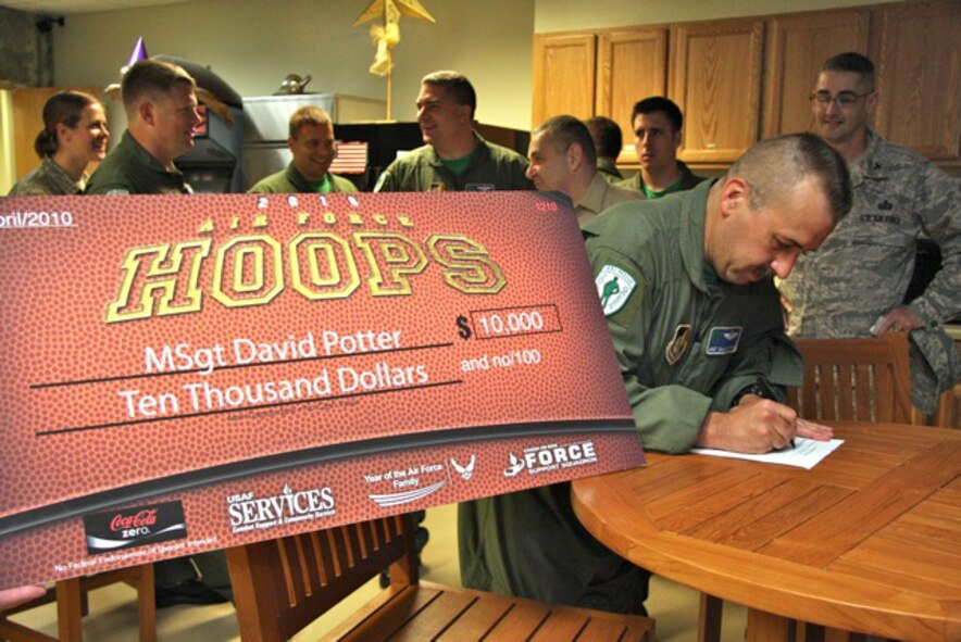 Master Sgt. David Potter, a flight engineer with the 33rd Rescue Squadron, signs for his $10,000 check at Kadena Air Base April 23. Sergeant Potter won the grand prize in the Air Force Hoops Contest sponsored by Air Force Services. (Courtesy photo)