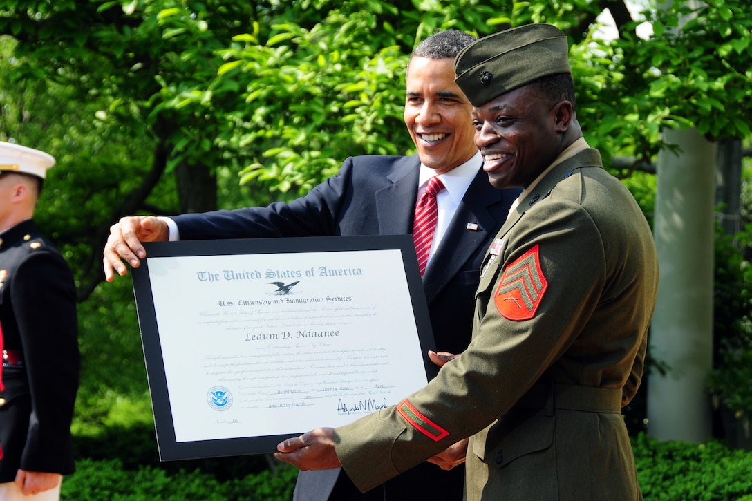 U.S. Marine Corps Sgt. Ledum D. Ndaanee poses with President Barack Obama holding the "Outstanding American by Choice" award re received from the president during a ceremony at the White House, April 23, 2010. The award highlights the importance of citizenship rights and responsibilities through recognition of the outstanding achievements of naturalized U.S. citizens. Ndaanee, originally from Nigeria, joined the U.S. Marine Corps in 2004, and became an American citizen in 2007. The award was giv U.S. Army photo by Todd Lopez