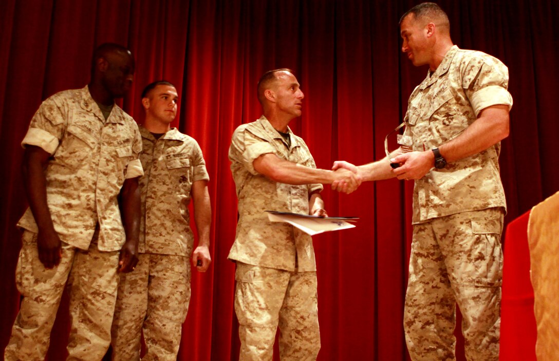 Lt. Col. Darrel L. Akers (right), executive officer, Combat Logistics Regiment 1, 1st Marine Logistics Group, accepts the Small Unit of the Year Award (149 volunteers or less), on behalf of Combat Logistics Regiment 1, from Col. Nicholas F. Marano (center), commanding officer, Marine Corps Base Camp Pendleton. Also on stage, representing the unit, is Capt. Darius L. James (left), commanding officer, Headquarters & Support Company and Cpl. Clinton Murray, electro-optical ordinance repairer. Camp Pendleton commemorated April’s National Volunteer Appreciation with its 11th annual Volunteer Recognition Ceremony, themed "Celebrating People in Action."