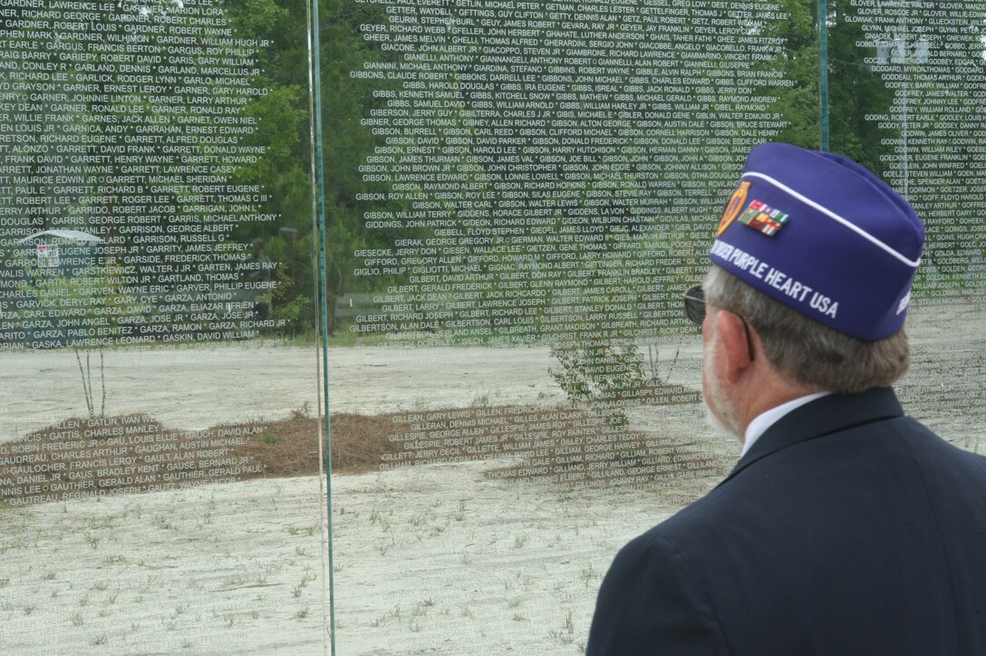 A member of the Order of the Purple Heart looks upon the walls of the Vietnam Veterans Memorial portion of the Lejeune Memorial Gardens after the Vietnam Recognition Day, April 24. The event is in remembrance of all Vietnam veterans and the mental and physical scars they live with every day.