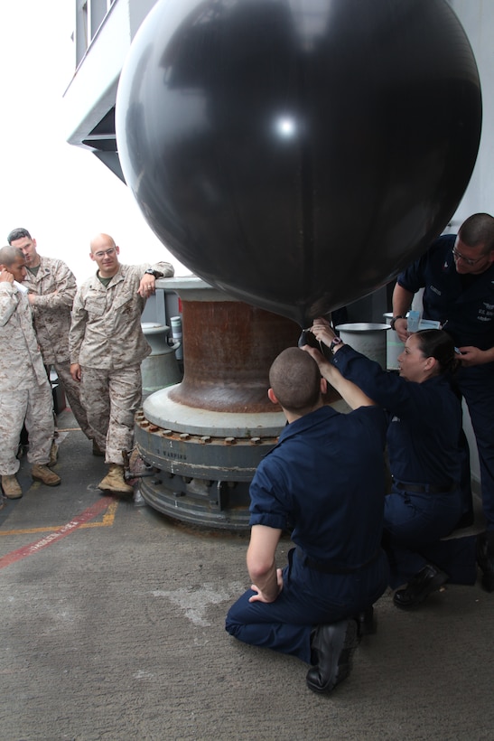 Marines with the communication section of 26th Marine Expeditionary Unit's command element watch as sailors with Meteorological and Oceanographic (METOC) section, Strike Group Oceanography Team (SGOT), Norfolk, Va., prepare a weather balloon for deployment during Amphibious Squadron (PHIBRON)/ Marine Expeditionary Unit Integration (PMINT) training exercise aboard USS Kearsarge near the coast of North Carolina, April 24, 2010. Attached to the weather balloon is a data transmission system which sends information to a receiver on the ship. METOC sailors and 26th Marine Expeditionary Unit weather forecasters use the data for real-time weather forecasting and analysis. 26th MEU is embarked aboard USS Kearsarge, USS Carter Hall, and USS New York for PMINT.
