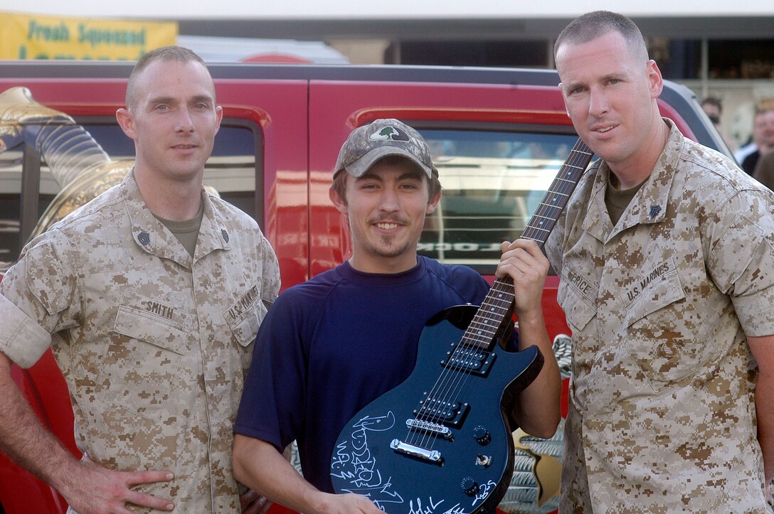 Marines of Recruiting Station Orlando present an autographed guitar to the raffle winner at 98 Rockfest in Tampa, Fla. The Marines were the guardians of the official "98 Rock Puddle of Mudd guitar."