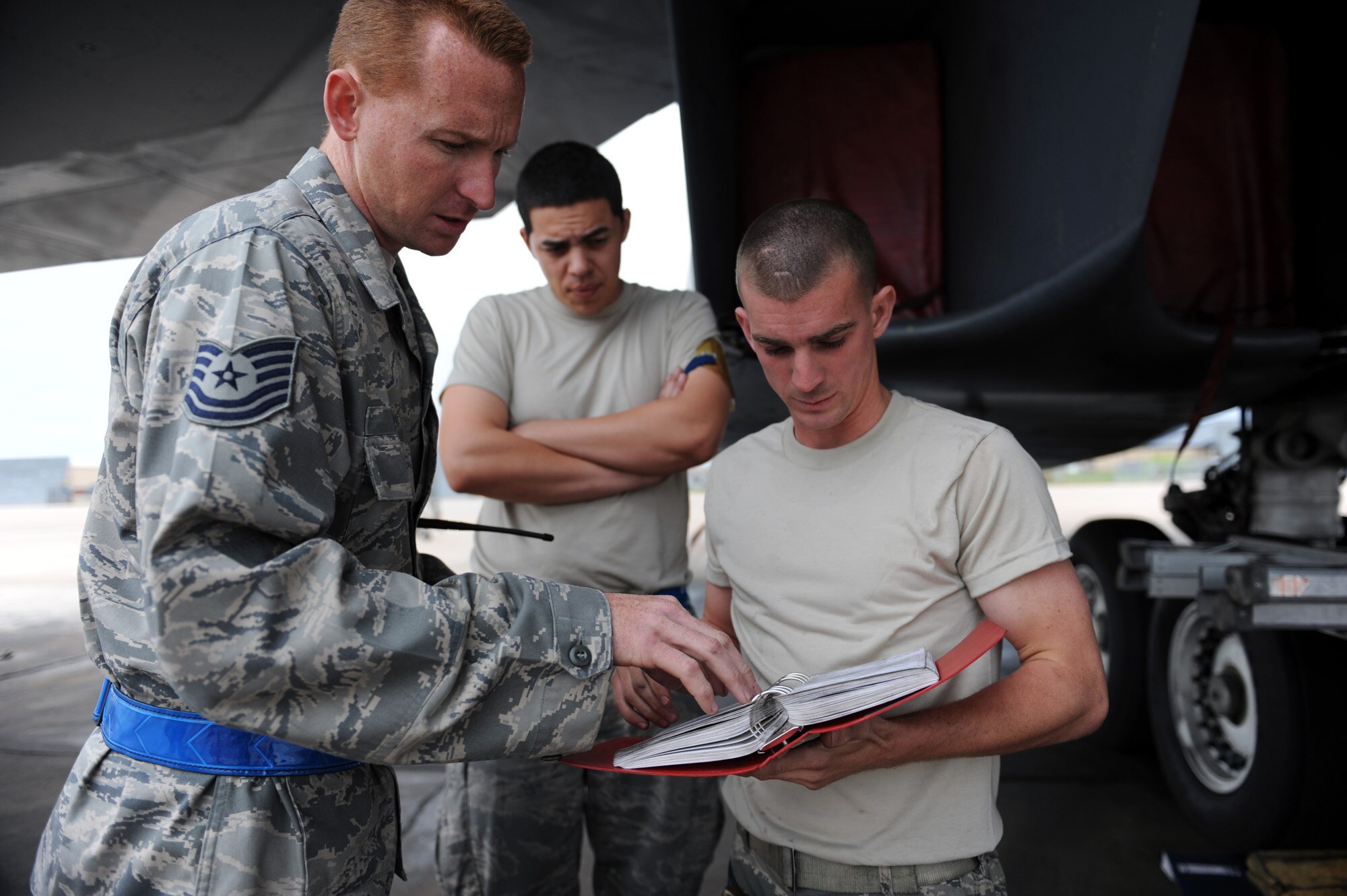Tech. Sgt. Jeffrey Hicks (left) shows Staff. Sgt. Christopher Blackwell and Airman 1st Class Antonio Herrera (background) a procedural step from the technical manual April 15, 2010, on the Dyess Air Force Base, Texas, flightline. Even though the mission of the B-1 Lancer has changed, the maintenance remains the same. (U.S. Air Force photo/Staff Sgt. Desiree N. Palacios)