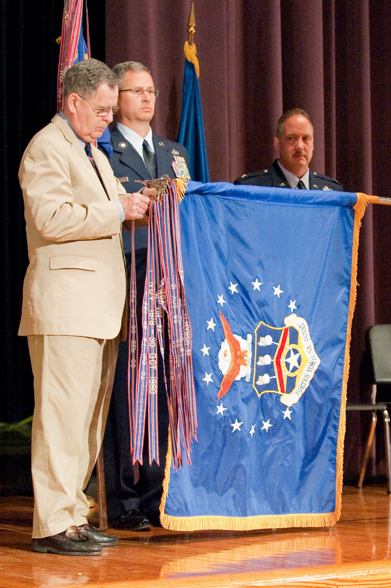 Dennis M. McCarthy, assistant secretary for Reserve Affairs (far left), pins a streamer representing the 123rd Airlift Wing's 14 Air Force Outstanding Unit Award onto the wing's guide-on during a ceremony held April 17, 2010, at Louisville Male High School in Louisville, Ky.  The 123rd Airlift Wing has now won more Air Force Outstanding Unit Awards than any other unit in the Air National Guard, officials said. Also pictured (from left to right) are Chief Master Sgt. James Smith, state command chief master sergeant for the Kentucky Air National Guard; Col. Gregory Nelson, commander of the 123rd Airlift Wing; and Chief Master Sgt. Curtis Carpenter, command chief master sergeant of the 123rd Airlift Wing. (U.S. Air Force photo/Maj. Dale Greer)