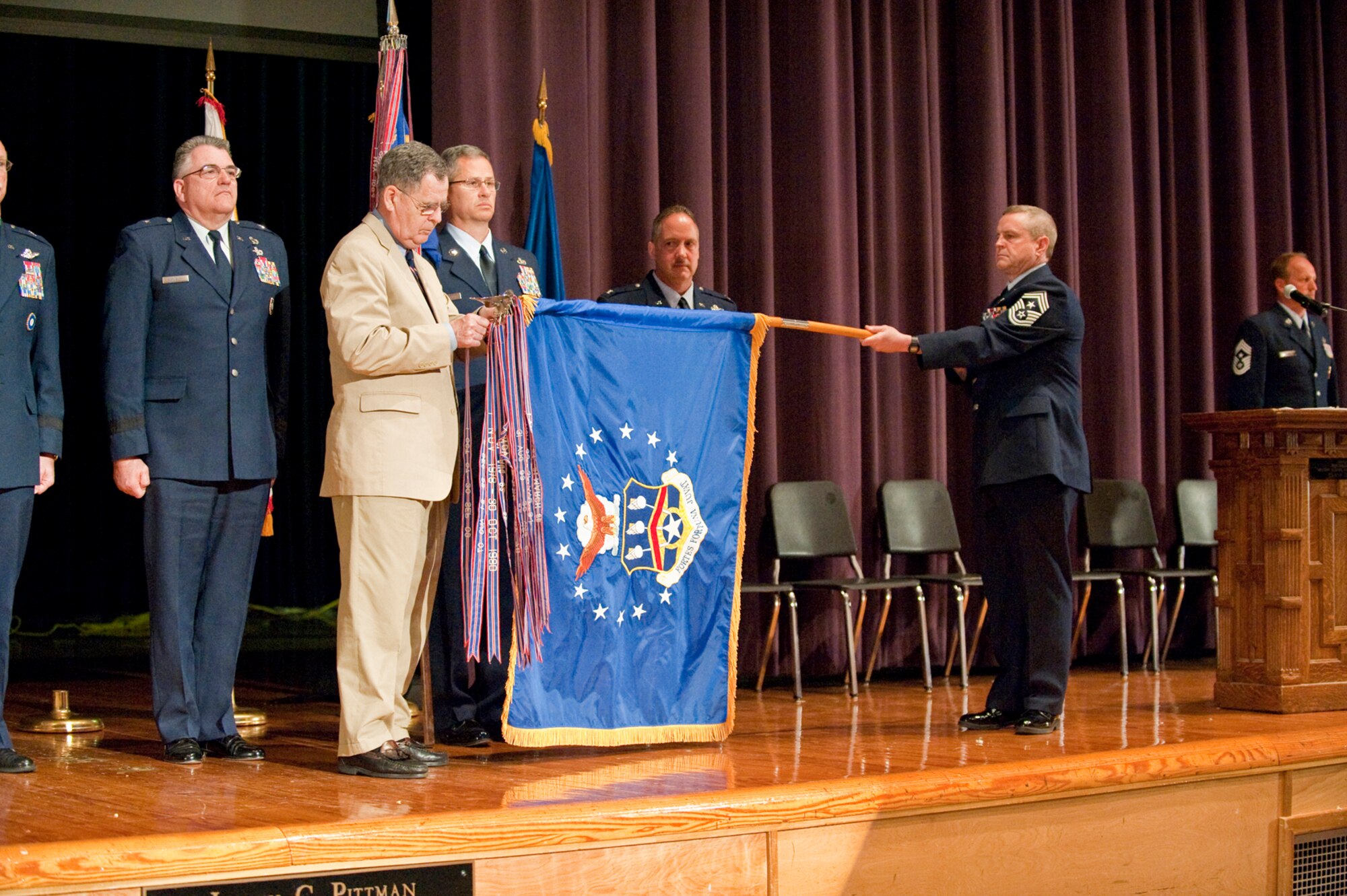 Dennis M. McCarthy, assistant secretary for Reserve Affairs (far left), pins a streamer representing the 123rd Airlift Wing's 14 Air Force Outstanding Unit Award onto the wing's guide-on during a ceremony held April 17, 2010 at Louisville Male High School in Louisville, Ky.  The 123rd Airlift Wing has now won more Air Force Outstanding Unit Awards than any other unit in the Air National Guard, officials said. Also pictured (from left to right) are Chief Master Sgt. James Smith, state command chief master sergeant for the Kentucky Air National Guard; Col. Gregory Nelson, commander of the 123rd Airlift Wing; and Chief Master Sgt. Curtis Carpenter, command chief master sergeant of the 123rd Airlift Wing. (U.S. Air Force photo/Maj. Dale Greer)