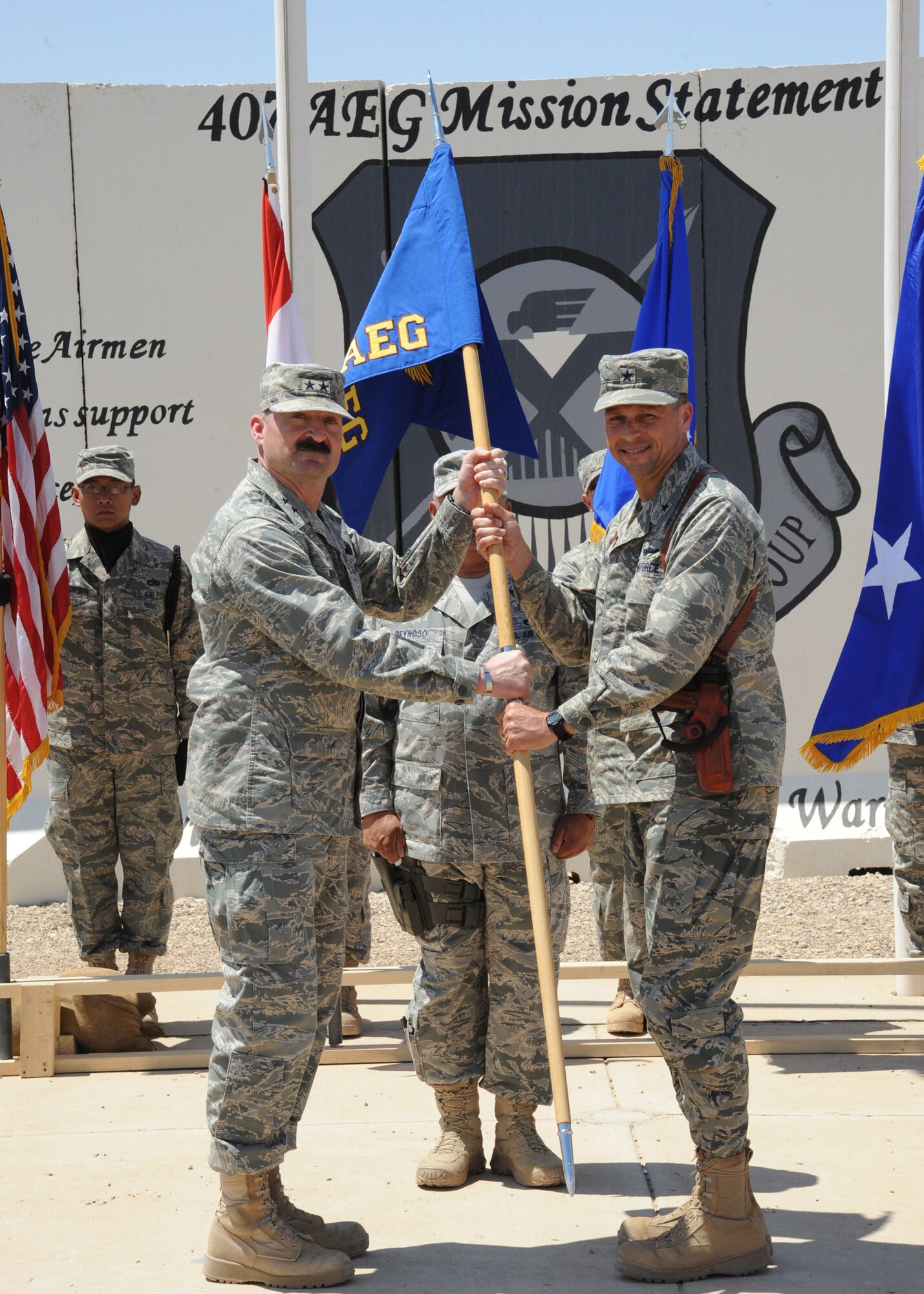 Air Force Maj. Gen. Joseph Reynes, Jr. (left), Director, Air Component Coordination Element, hands the guidon to Brig. Gen. Scott Hanson, commander of the 321st Air Expeditionary Wing, during a transfer of authority from the 332nd AEW to the 321st, AEW Ali Air Base, Iraq, April 24, 2010. The mission of the 321st AEW is to train and advise the Iraqi air force in order to advance the foundational airpower capabilities of Iraqi Airmen. (U.S. Air Force photo/Master Sgt. Trish Bunting/Released)