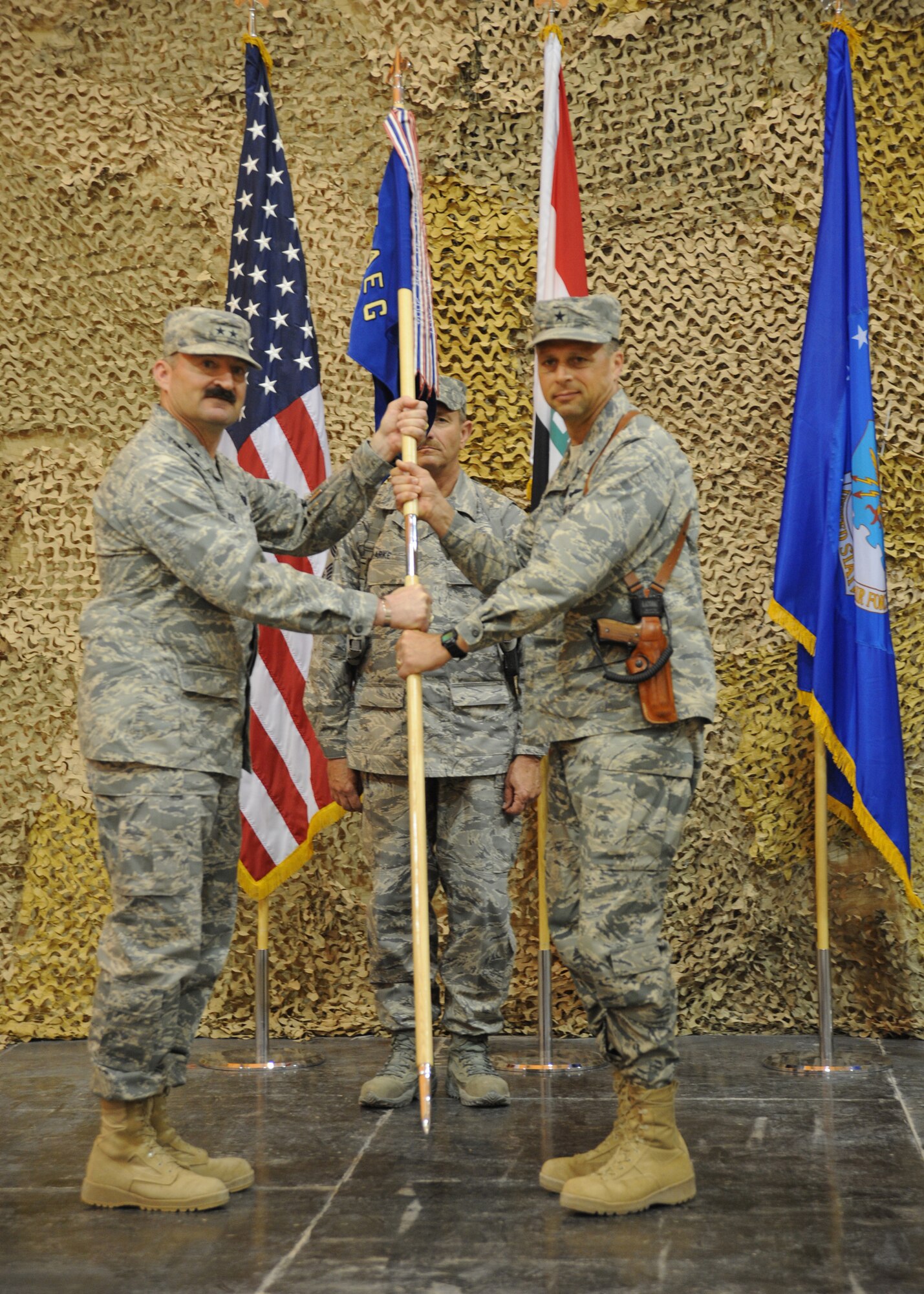 Air Force Maj. Gen. Joseph Reynes, Jr. (left), Director, Air Component Coordination Element, hands the guidon to Brig. Gen. Scott Hanson, commander of the 321st Air Expeditionary Wing, during a transfer of authority from the 332nd AEW to the 321st, AEW Ali Air Base, Iraq, April 24, 2010. The mission of the 321st AEW is to train and advise the Iraqi air force in order to advance the foundational airpower capabilities of Iraqi Airmen. (U.S. Air Force photo/Master Sgt. Trish Bunting/Released)