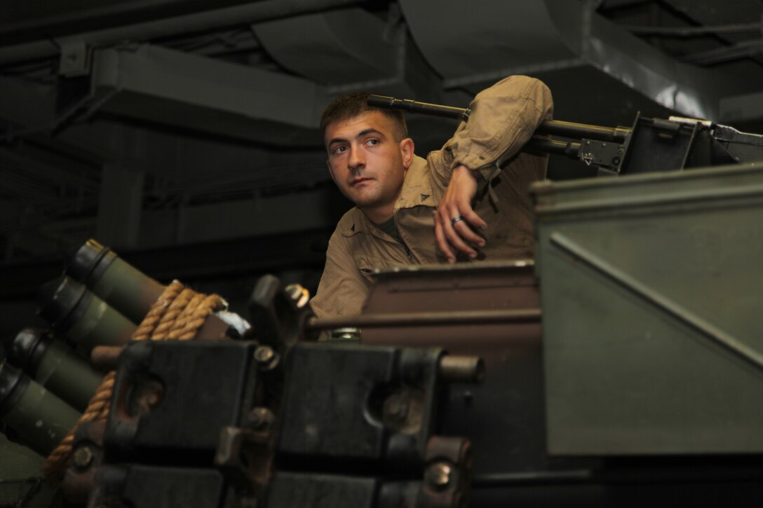 Lance Cpl. William A. Seniw, a loader specialist with Battalion Landing Team 3/8, Weapons Company, 26th Marine Expeditionary Unit, sits atop an M1A1 Main Battle Tank in preparation for loading onto Landing Craft Air Cushioned aboard USS Kearsarge, off the shore of Camp Lejeune, N.C., April 26, 2010. 26th MEU is embarked aboard USS Kearsarge, USS Carter Hall, and USS New York for Amphibious Squadron (PHIBRON)/ Marine Expeditionary Unit Integration (PMINT) training. PMINT integrates 26th MEU Marines with their Navy counterparts to train in planning and execution of missions they could conduct when they deploy together this fall. ::r::::n::::r::::n::