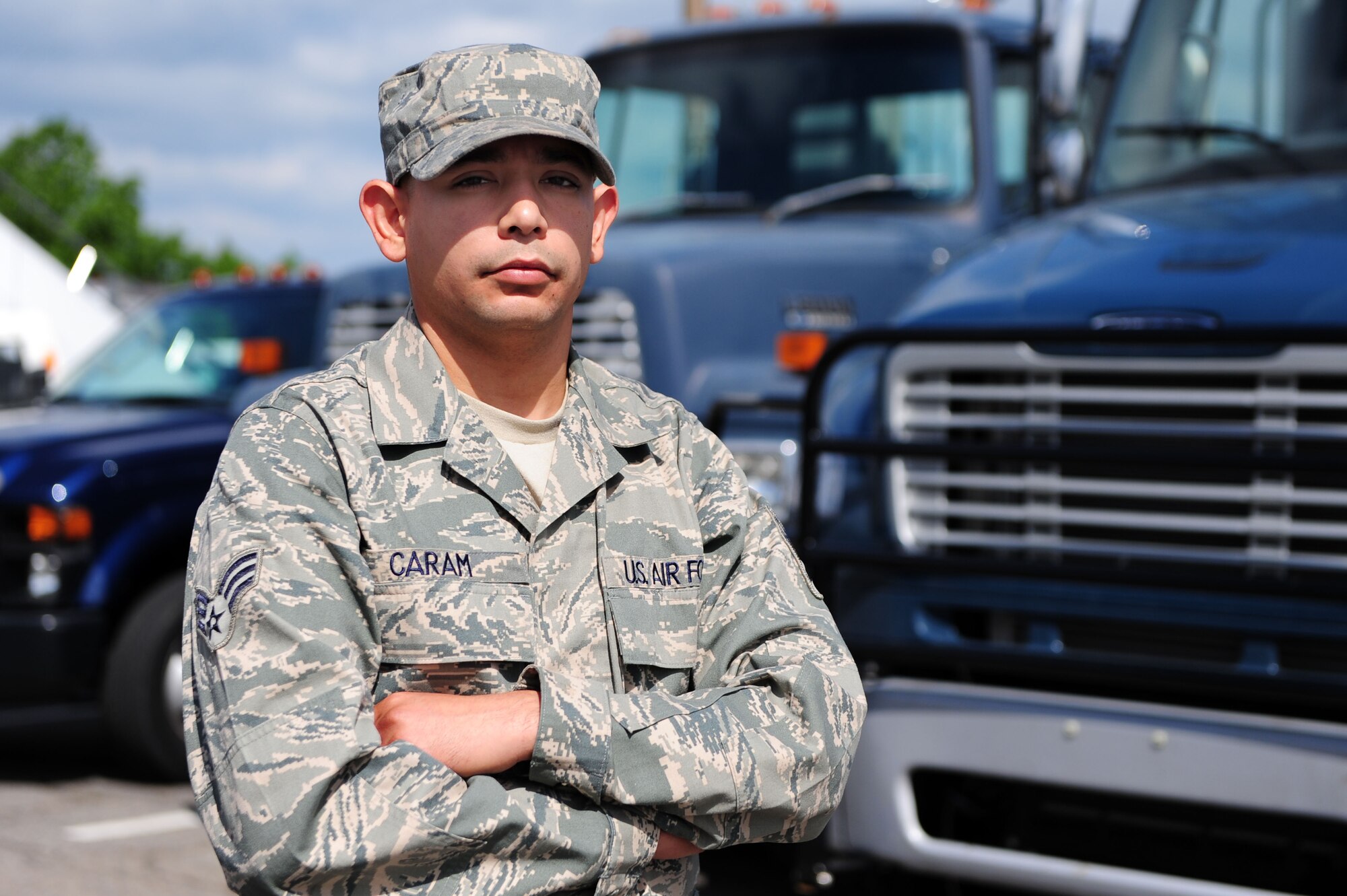 Senior Airman William Caram, 19th Logistics Readiness Squadron vehicle maintenance customer service journeyman, stands April 26 with vehicles he maintains on base. Airman Caram was recently recognized at the Air Force-level for his dedication to vehicle maintenance and the logistics readiness career field. (U.S. Air Force photo by Senior Airman Steele C. G. Britton)