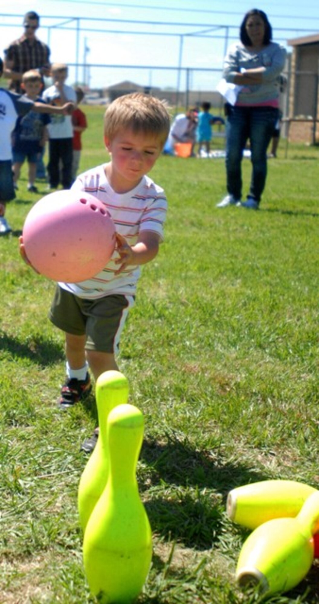 Isaac Kauffung, 3, aims for his last two pins as he tries to pick up a spare at the Children’s Festival April 24. More than 450 families attended the event and almost 4,500 prizes were won. (U.S. Air Force photo/Connie Hempel)