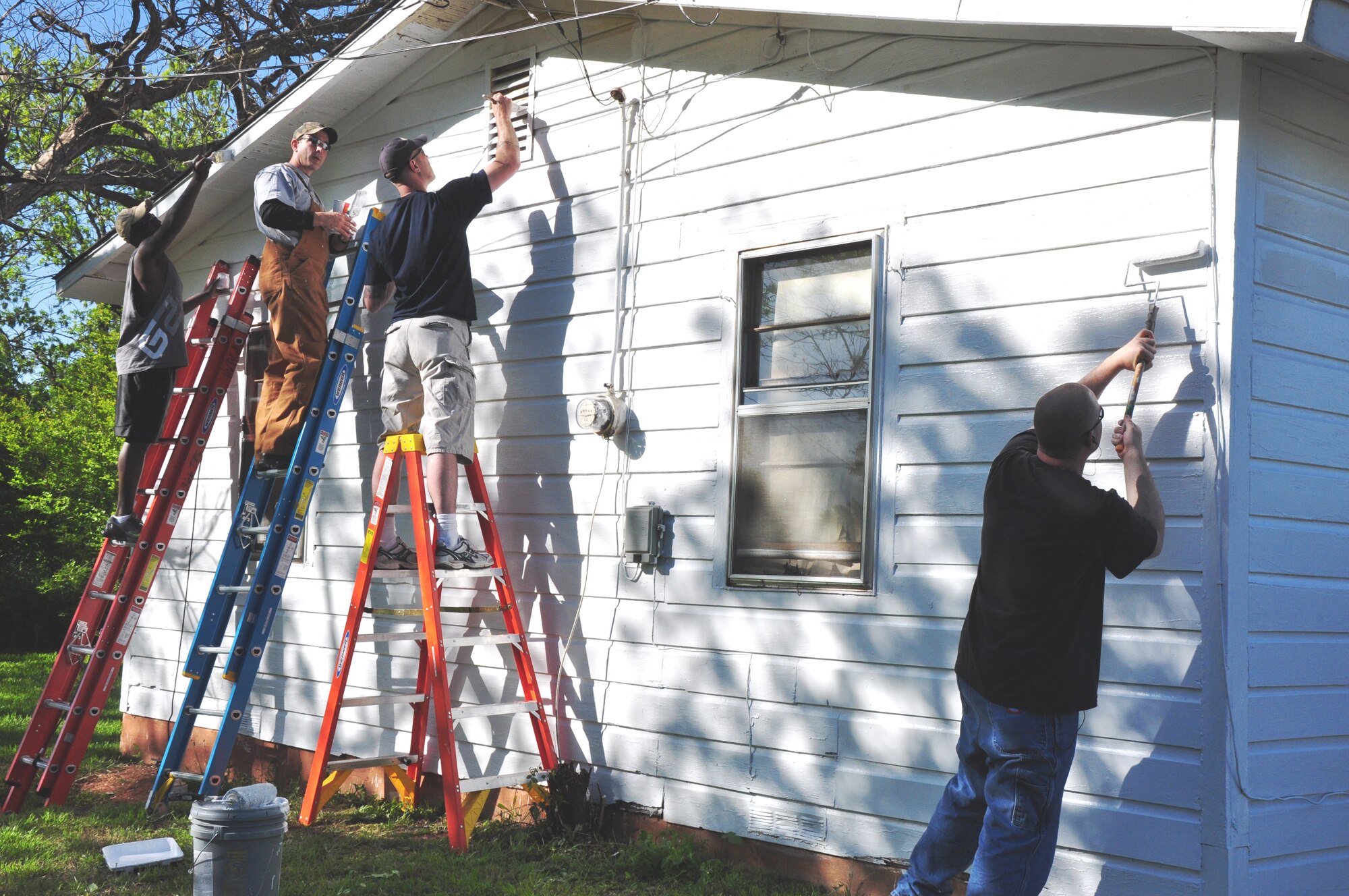Members of the 366th Training Squadron paint the exterior of a Wichita Falls, Texas, home during Christmas in Action April 24, 2010. Christmas in Action is a program that has renovated the homes of low-income elderly and disabled homeowners in Wichita County for 27 years. (U.S. Air Force photo/Airman 1st Class Valerie Hosea)