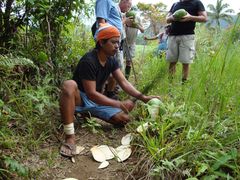 TACLOBAN, Philippines -- A local guide takes time to cut down some coconuts as a refreshing treat for the crew of Moore’s Marauders, who had been in the jungle for more than three hours. Moore’s Marauders is a nonprofit organization that devotes its efforts to find the World War II remains of a six-man C-47 Skytrain crew that disappeared while delivering supplies to guerilla forces. (Photo courtesy of Senior Master Sgt. Thomas Niznik/RELEASED) 